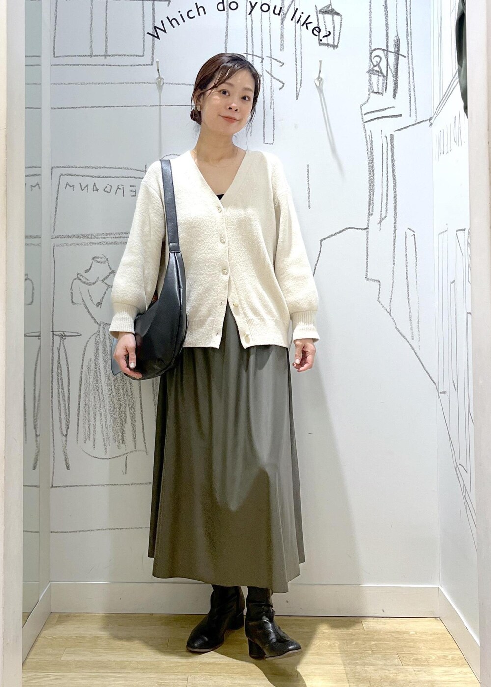 グリーン系のスカート、ホワイト系のカーディガン/ボレロ、ブラック系のショルダーバッグを着用したレディースの秋コーディネートの5枚目の写真