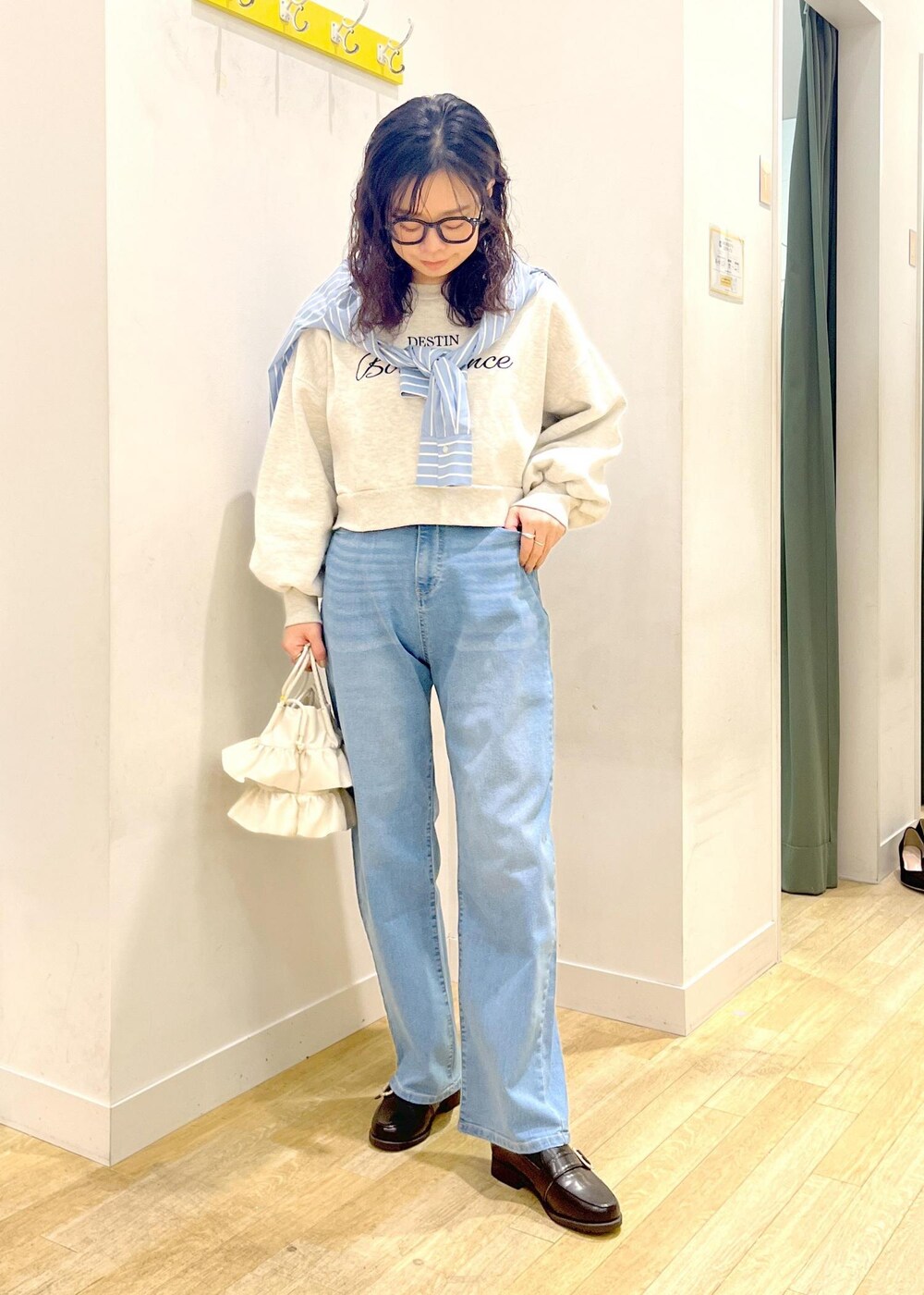 ホワイト系のショルダーバッグ、ブラック系のローファー、グレー系のスウェットを着用したレディースの冬コーディネートの2枚目の写真