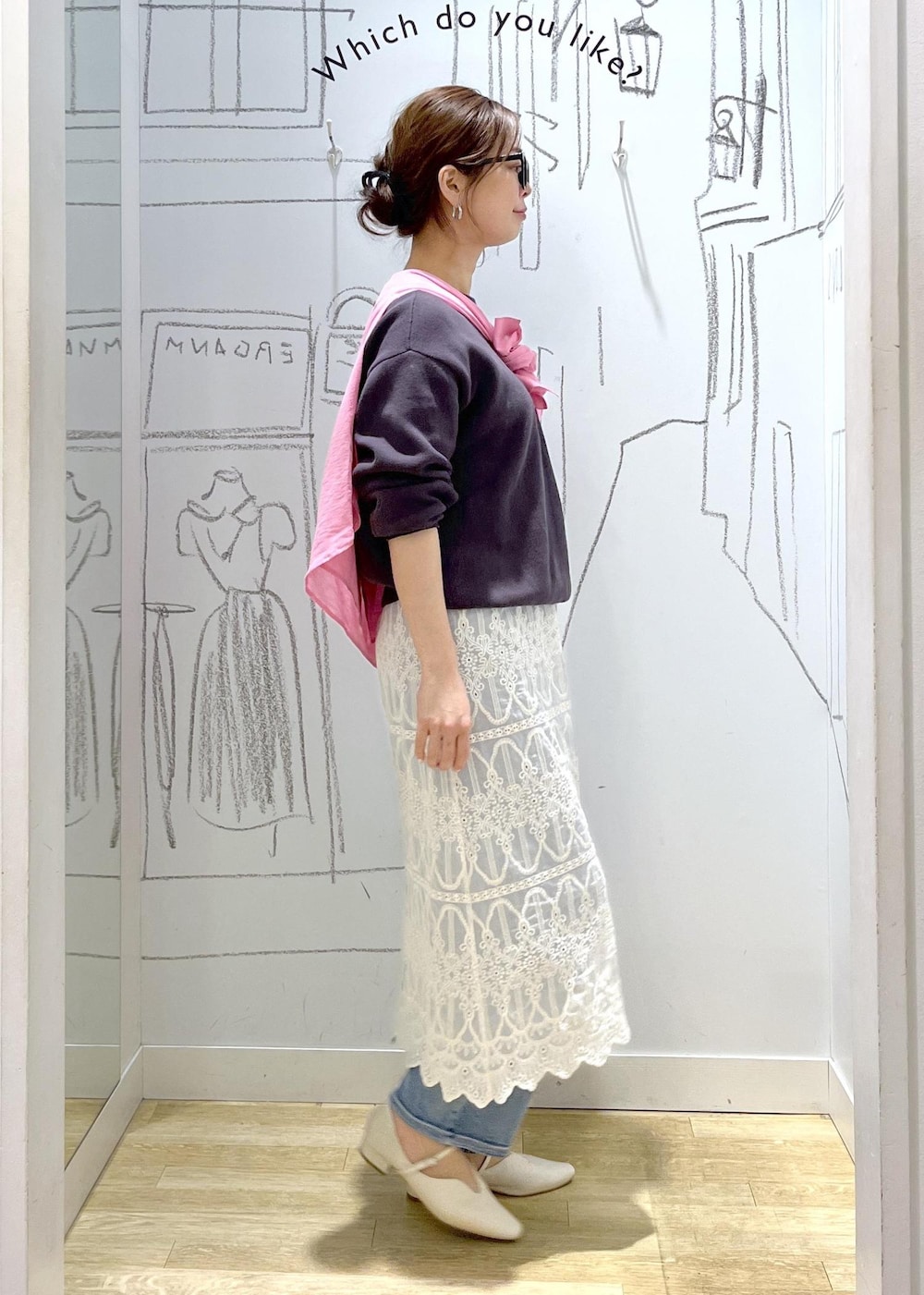 グレー系のニット/セーター、ブルー系のデニムパンツ、ホワイト系のワンピースを着用したレディースの春コーディネートの3枚目の写真