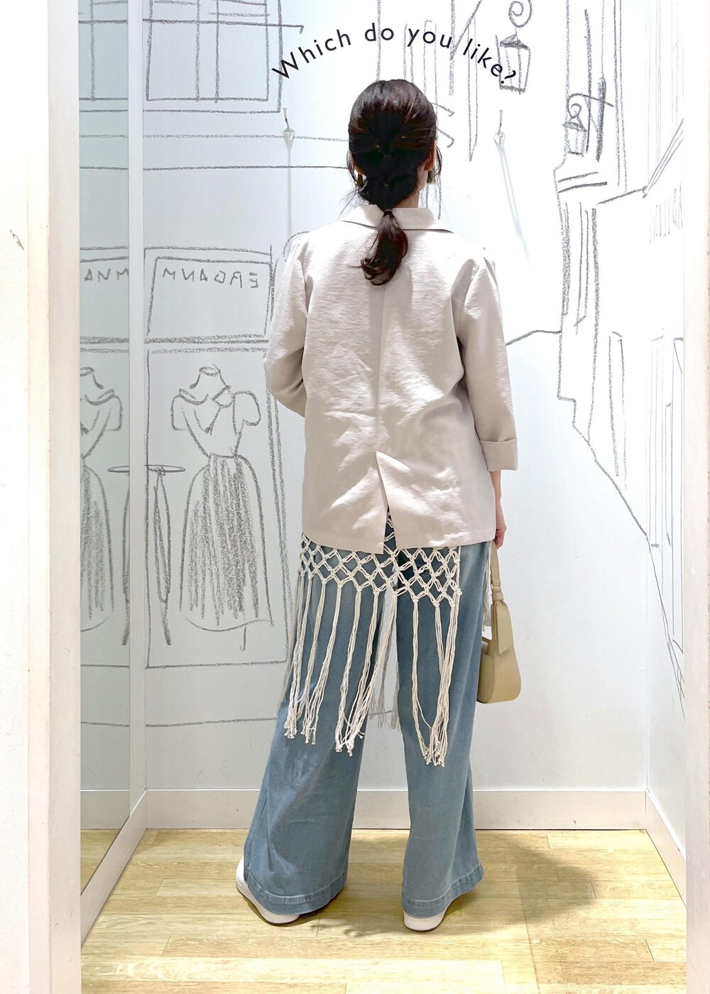 ベージュ系のハンドバッグ、ブルー系のデニムパンツ、ホワイト系のスカートを着用したレディースの春コーディネートの5枚目の写真