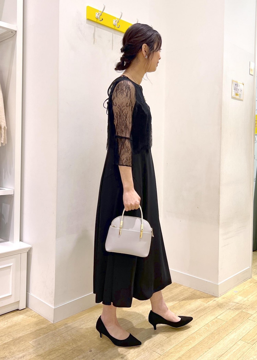 ホワイト系のショルダーバッグ、ブラック系のドレスを着用したレディースの冬コーディネートの4枚目の写真