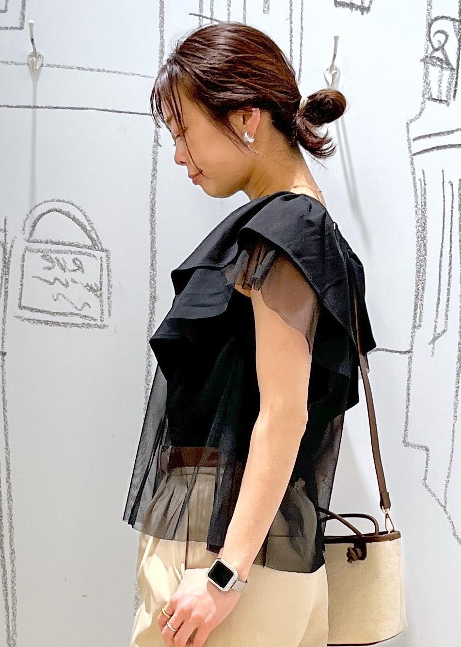 ベージュ系のチノパンツ、ブラウン系のトートバッグ、ブラック系のTシャツ/カットソーを着用したレディースの春コーディネートの9枚目の写真