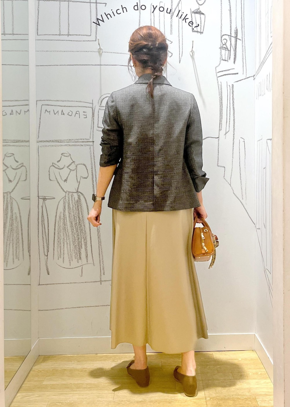 グレー系のテーラードジャケット、ベージュ系のスカート、ブラウン系のパンプスを着用したレディースの秋コーディネートの5枚目の写真
