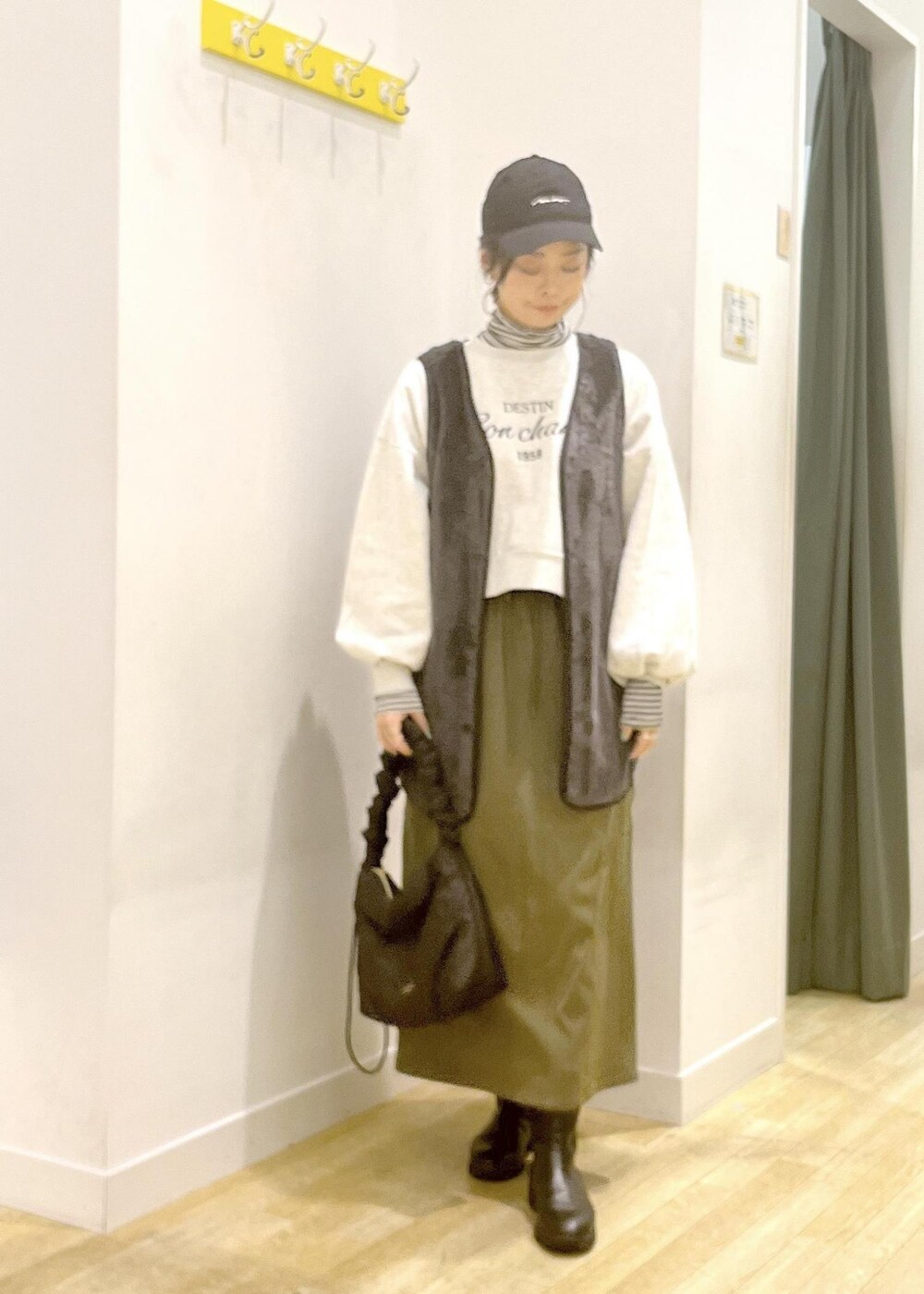 ホワイト系のTシャツ/カットソー、ブラック系のその他アウター、グレー系のスウェットを着用したレディースの冬コーディネートの3枚目の写真