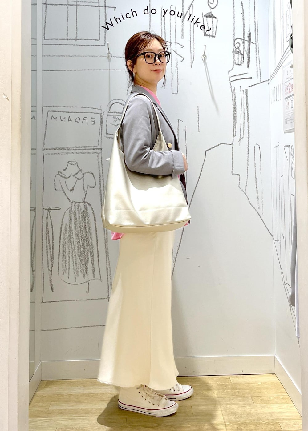 シルバー系のトートバッグ、グレー系のベスト、ホワイト系のスカートを着用したレディースの春コーディネートの5枚目の写真
