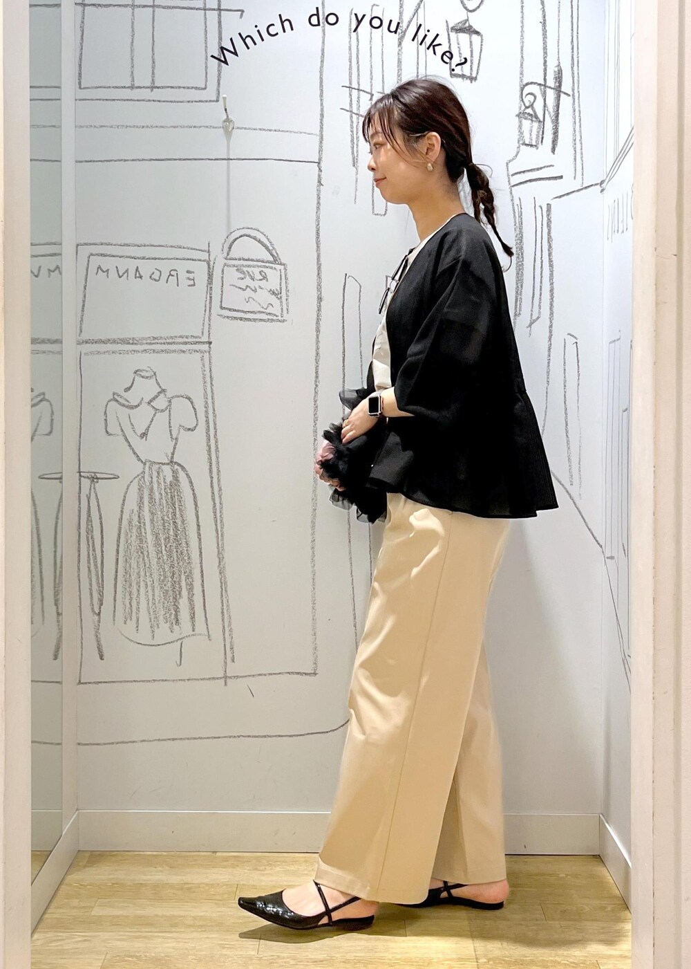 ブラック系のショルダーバッグ、ベージュ系のチノパンツ、ブラック系のブルゾンを着用したレディースの春コーディネートの6枚目の写真