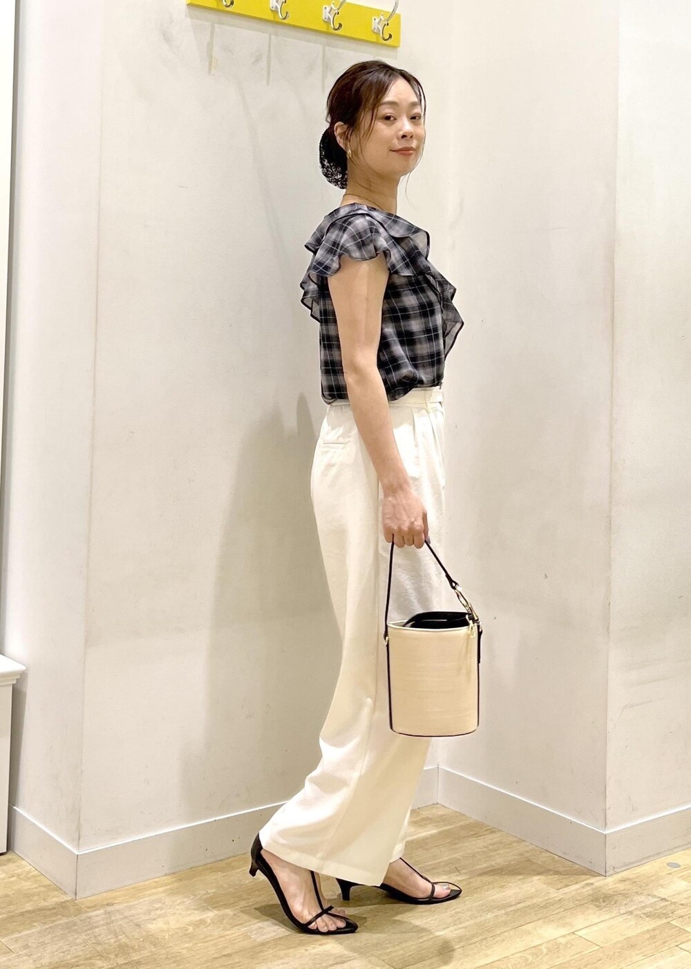 ブラック系のハンドバッグ、ホワイト系のその他パンツ、ブラック系のシャツ/ブラウスを着用したレディースの夏コーディネートの3枚目の写真