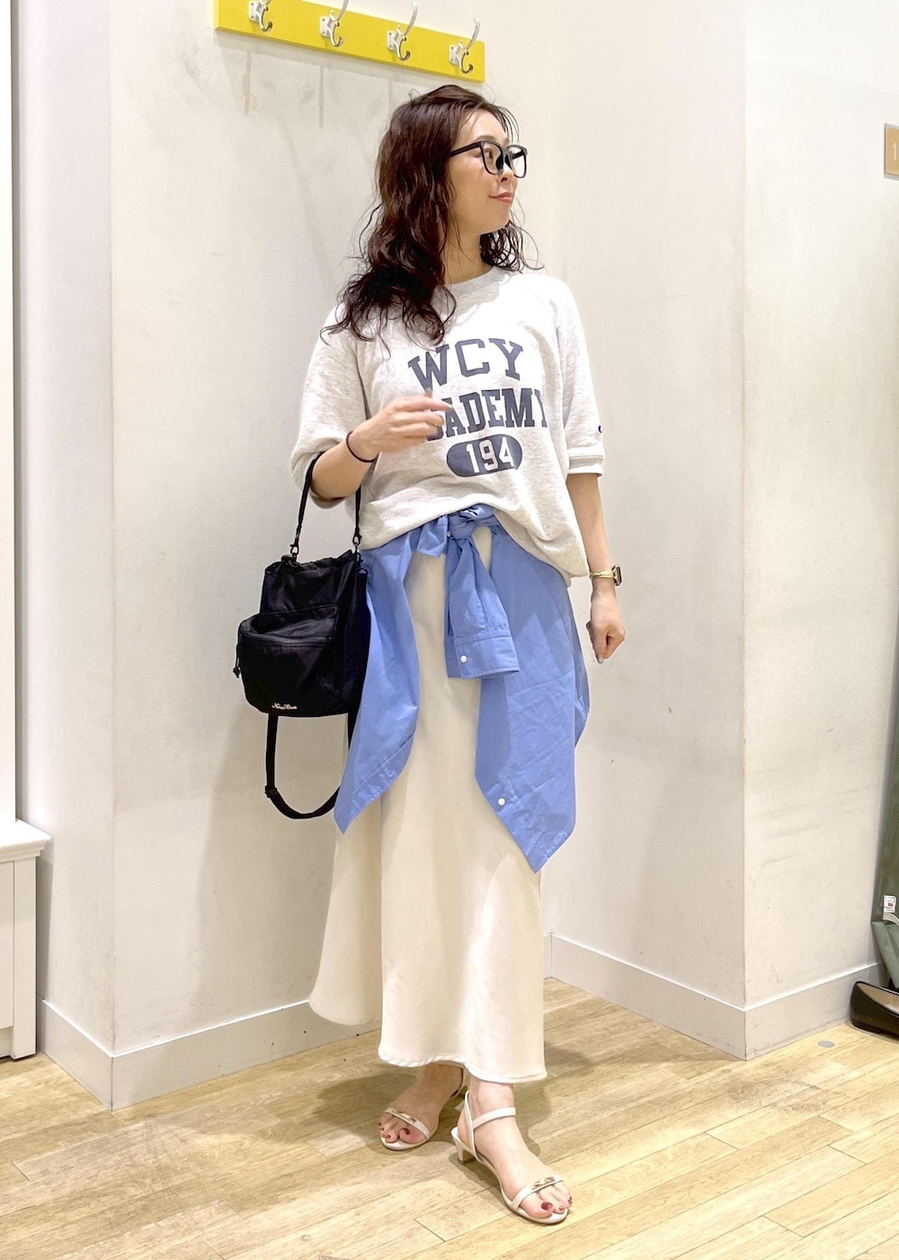 ホワイト系のスカート、ブルー系のシャツ/ブラウス、グレー系のTシャツ/カットソーを着用したレディースの夏コーディネートの2枚目の写真