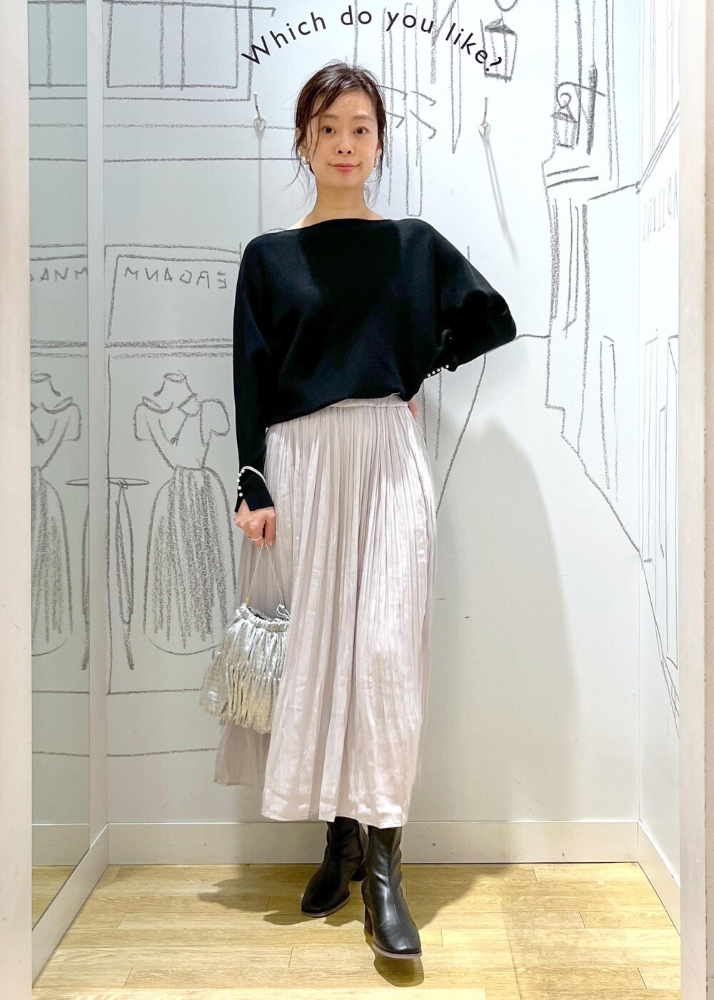 ブラック系のノーカラージャケット、ブラック系のブーツ、シルバー系のショルダーバッグを着用したレディースの冬コーディネートの2枚目の写真