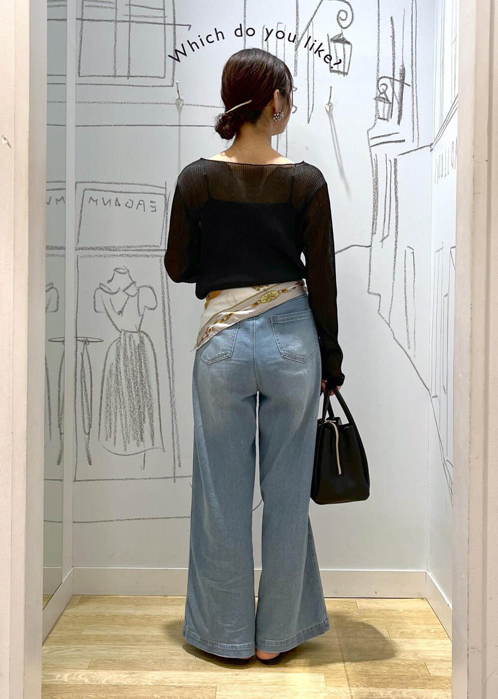 ブラック系のショルダーバッグ、ブラック系のTシャツ/カットソー、ブルー系のデニムパンツを着用したレディースの春コーディネートの6枚目の写真