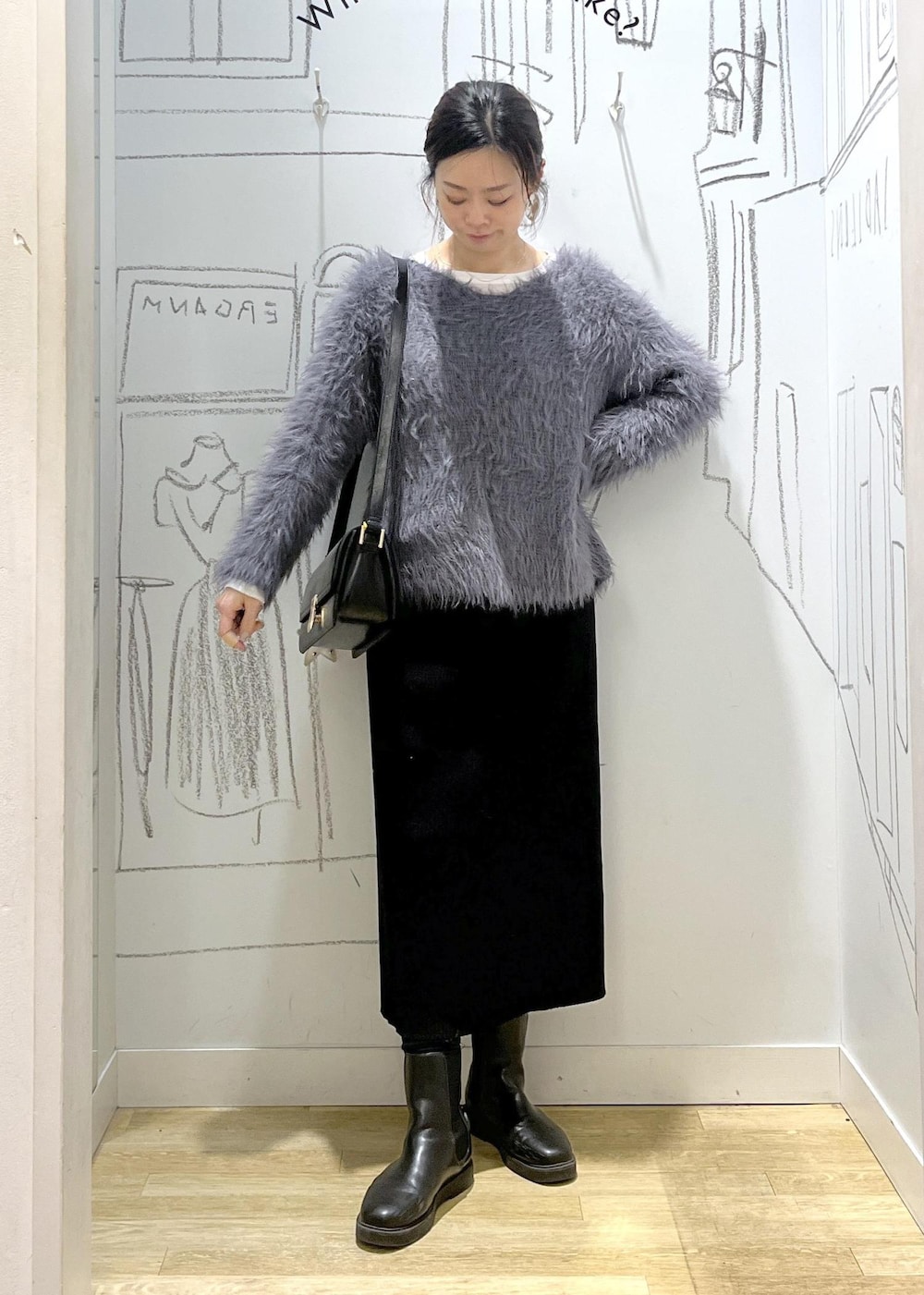 ブラック系のショルダーバッグ、ブラック系のスカート、ホワイト系のTシャツ/カットソーを着用したレディースの冬コーディネートの2枚目の写真