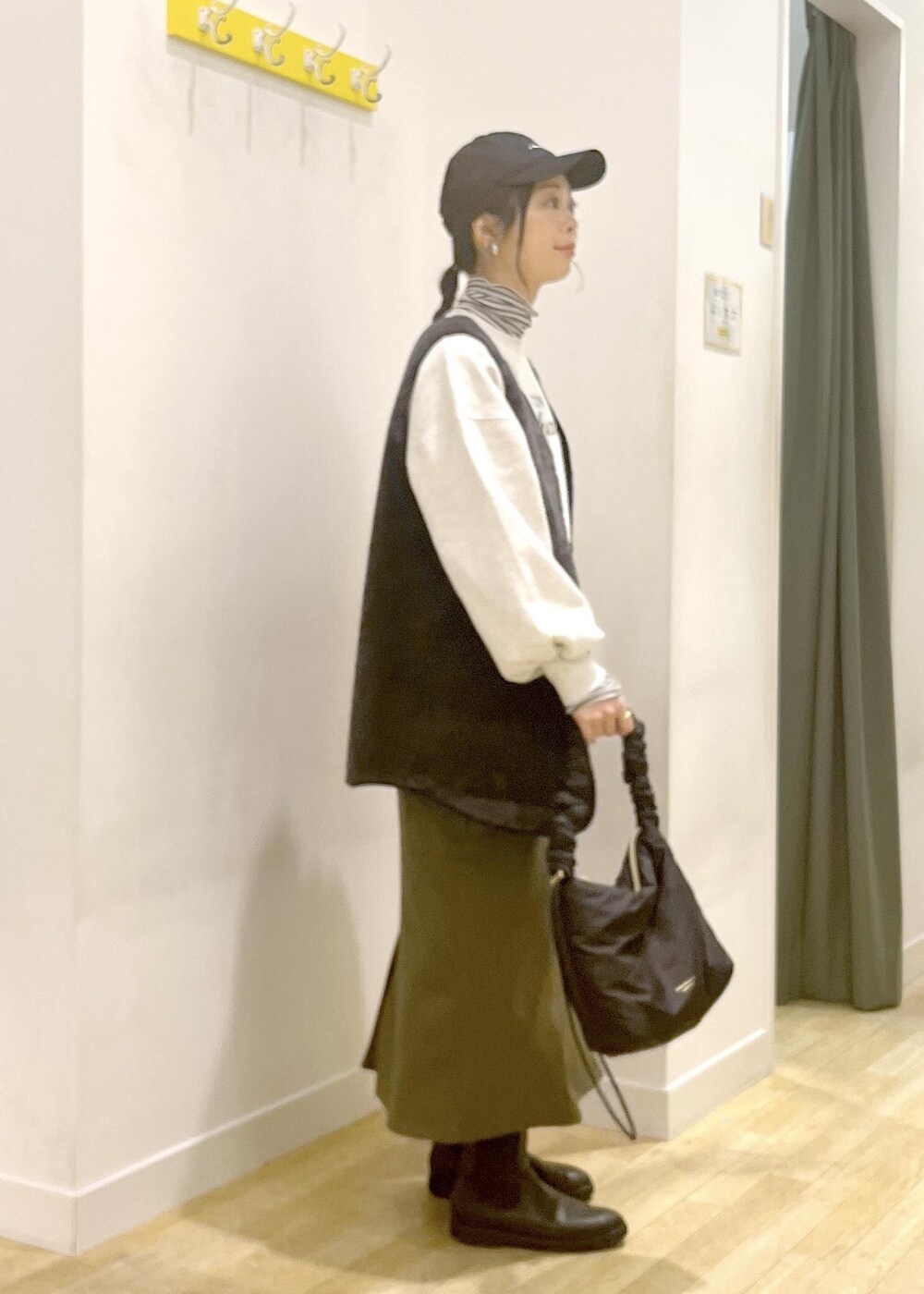 ホワイト系のTシャツ/カットソー、ブラック系のその他アウター、グレー系のスウェットを着用したレディースの冬コーディネートの2枚目の写真