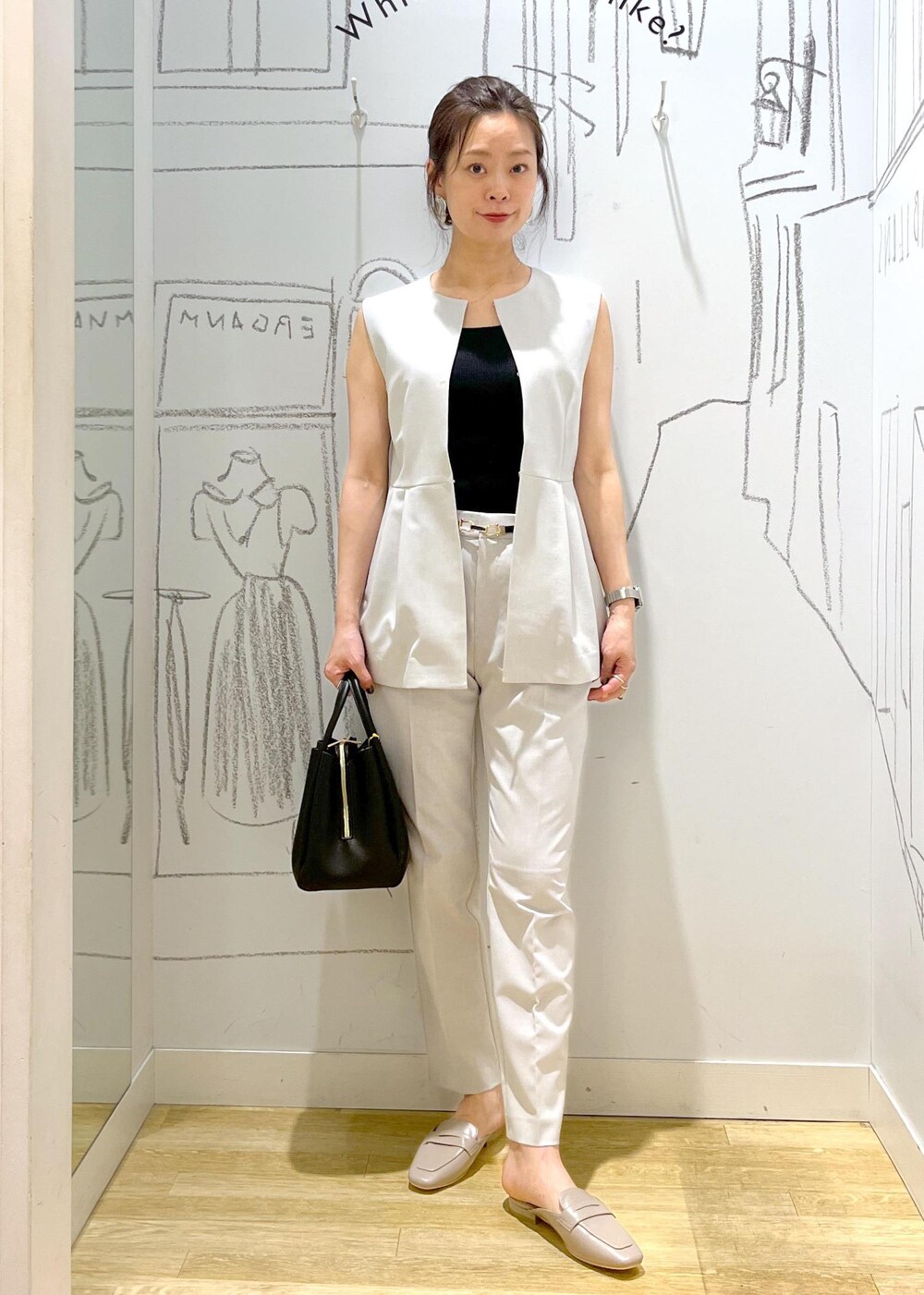 ブラック系のショルダーバッグ、グレー系のローファー、グレー系のスラックスを着用したレディースの夏コーディネートの7枚目の写真