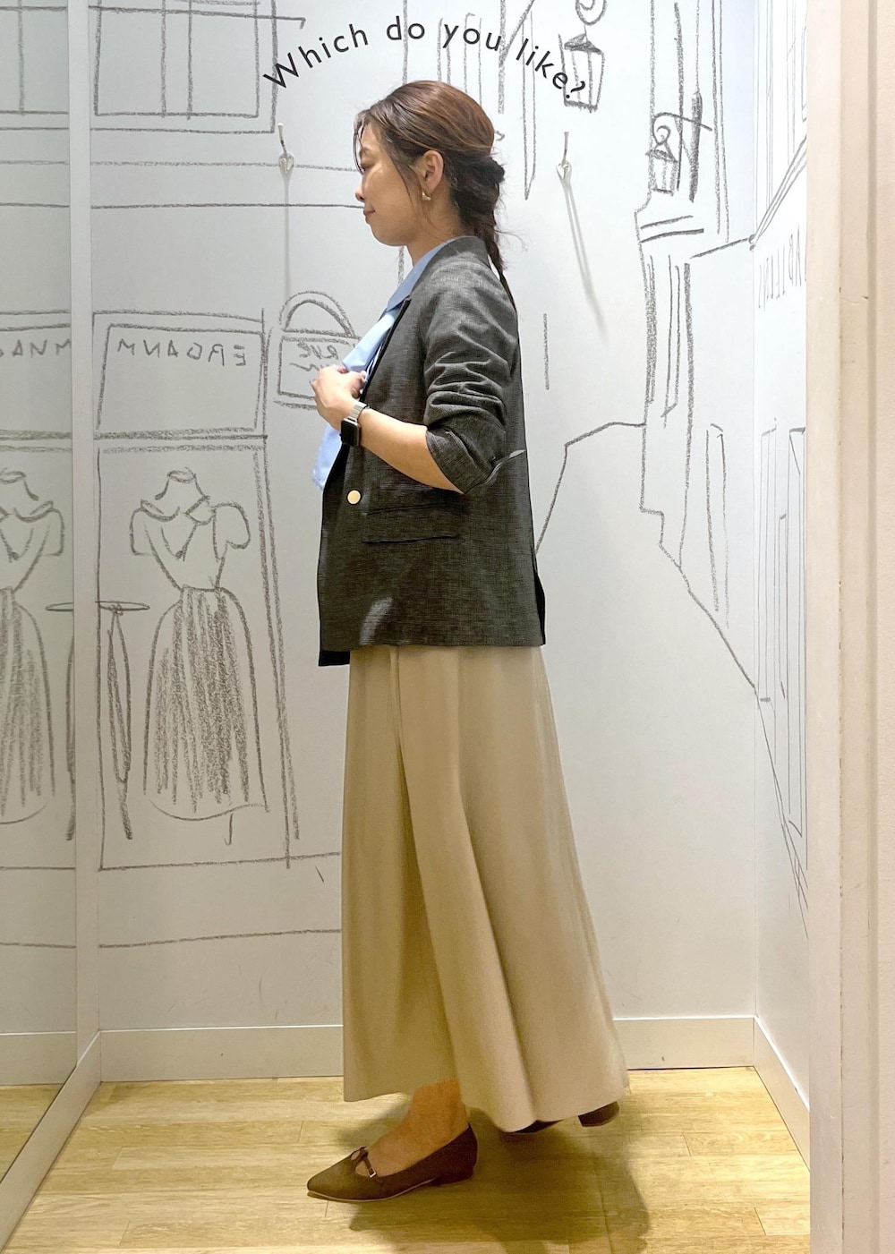 グレー系のテーラードジャケット、ベージュ系のスカート、ブラウン系のパンプスを着用したレディースの秋コーディネートの4枚目の写真