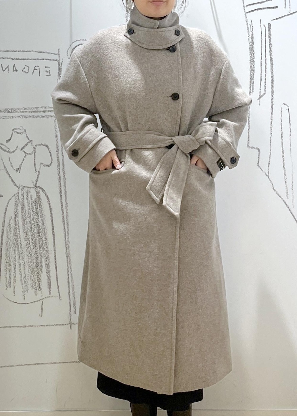 ブラック系のショルダーバッグ、ブラック系のスカート、ベージュ系のチェスターコートを着用したレディースの冬コーディネートの8枚目の写真