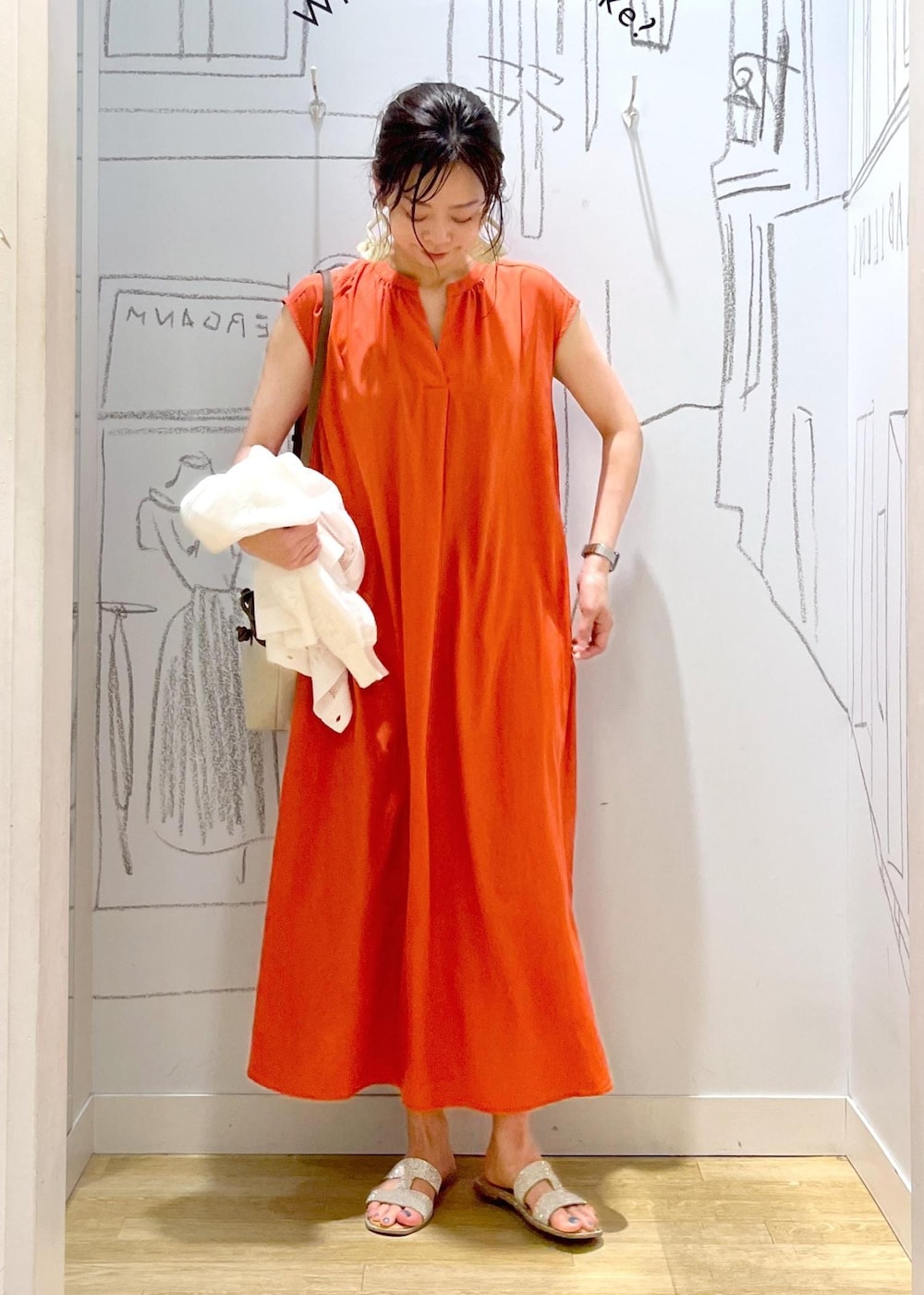 ブラウン系のトートバッグ、オレンジ系のワンピースを着用したレディースの夏コーディネートの3枚目の写真