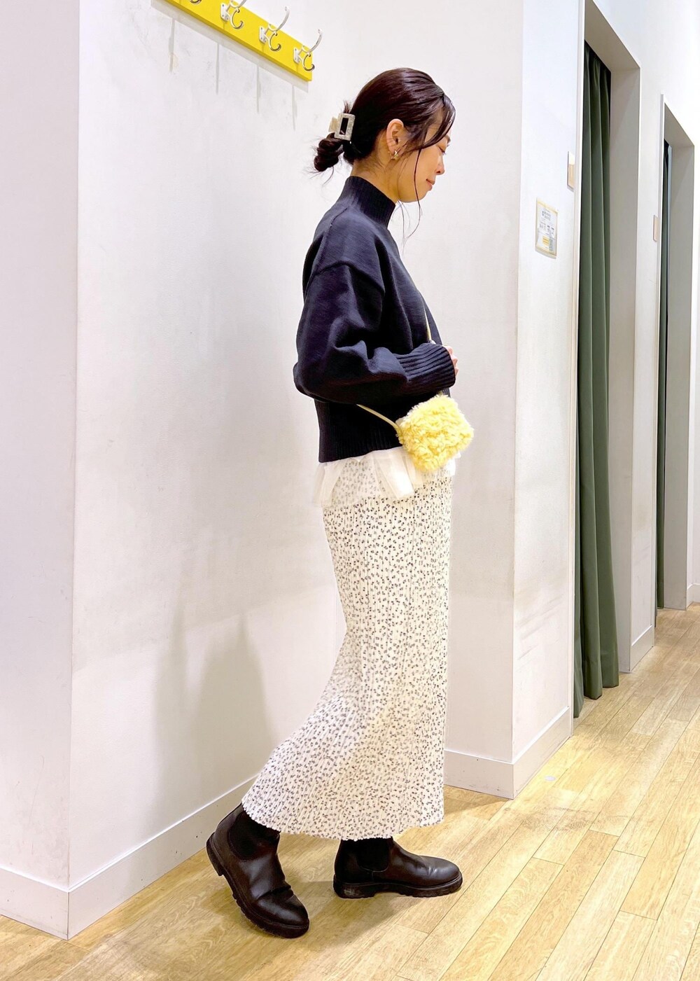 ブラック系のニット/セーター、グレー系のショルダーバッグ、ホワイト系のスカートを着用したレディースの冬コーディネートの2枚目の写真