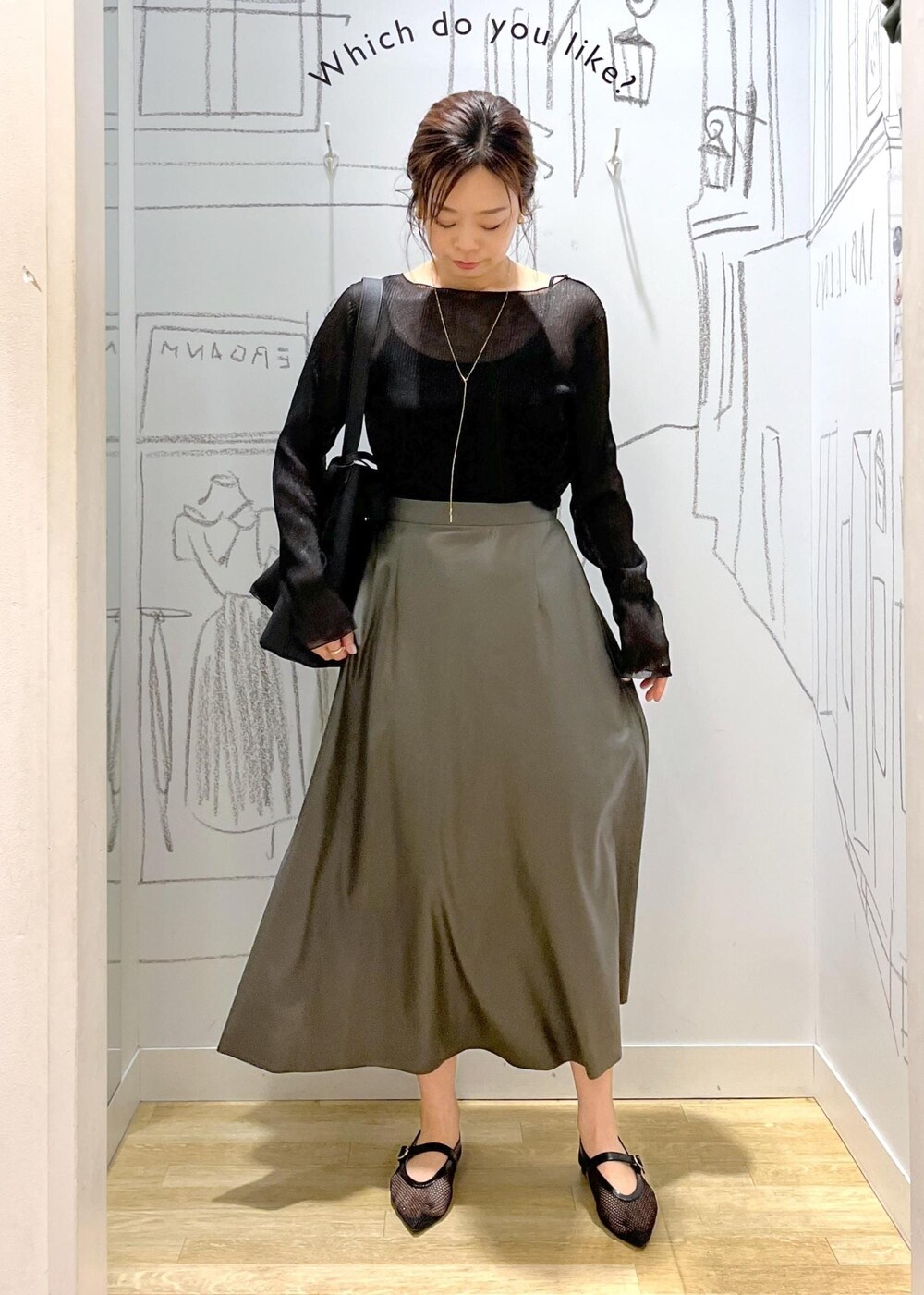 ブラック系のTシャツ/カットソー、ブラック系のショルダーバッグ、グリーン系のスカートを着用したレディースの秋コーディネートの2枚目の写真