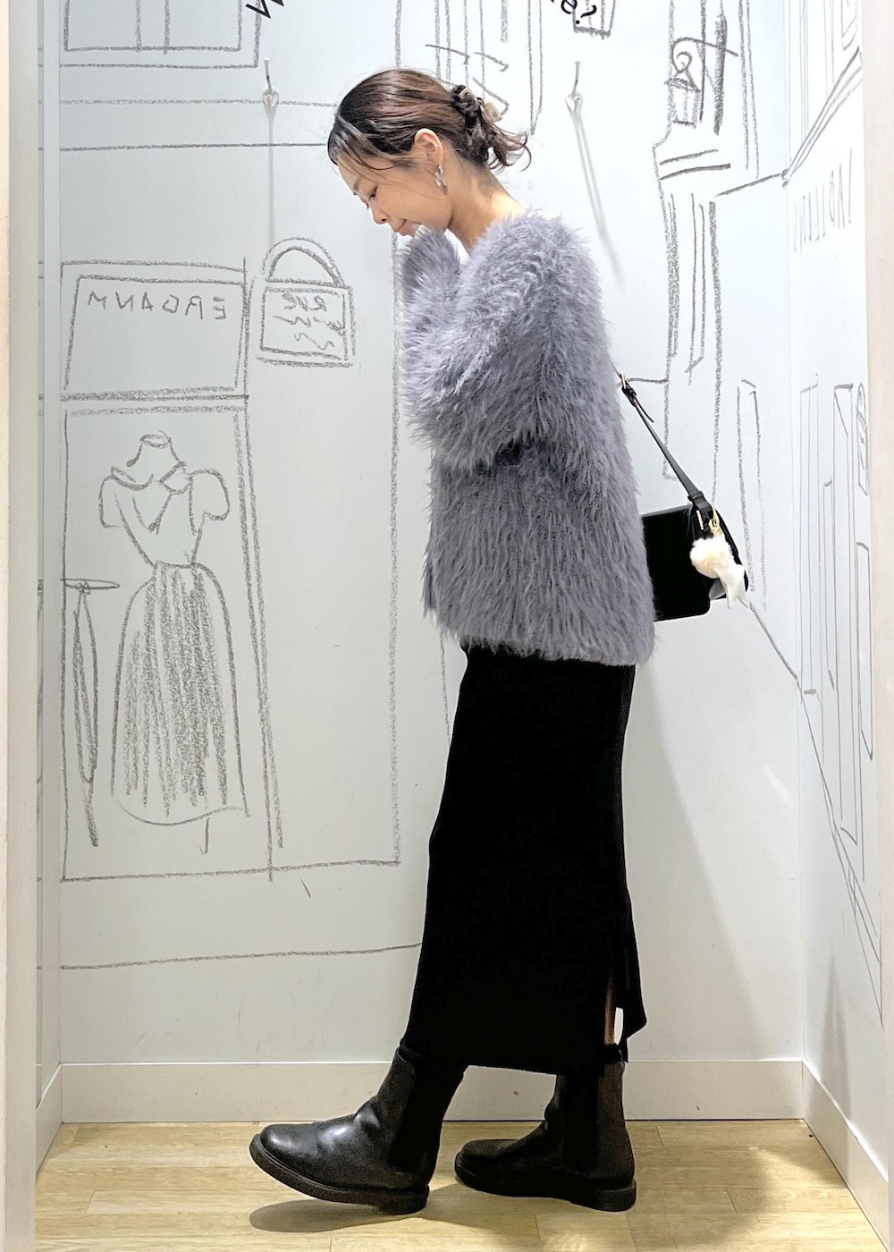 ブラック系のショルダーバッグ、ブラック系のスカート、ホワイト系のTシャツ/カットソーを着用したレディースの冬コーディネートの3枚目の写真