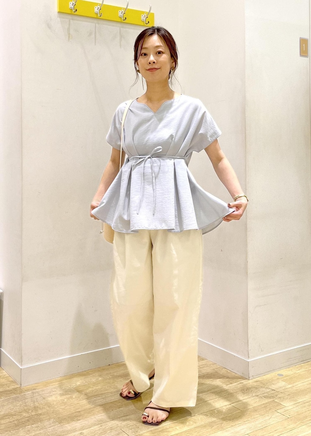 ブルー系のシャツ/ブラウス、ホワイト系のチノパンツ、ホワイト系のハンドバッグを着用したレディースの夏コーディネートの3枚目の写真