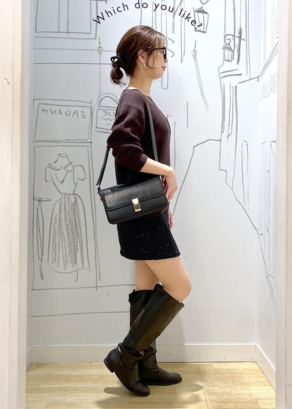 ブラック系のショルダーバッグ、ブラウン系のニット/セーター、ブラック系のダウンジャケット/コートを着用したレディースの冬コーディネートの5枚目の写真