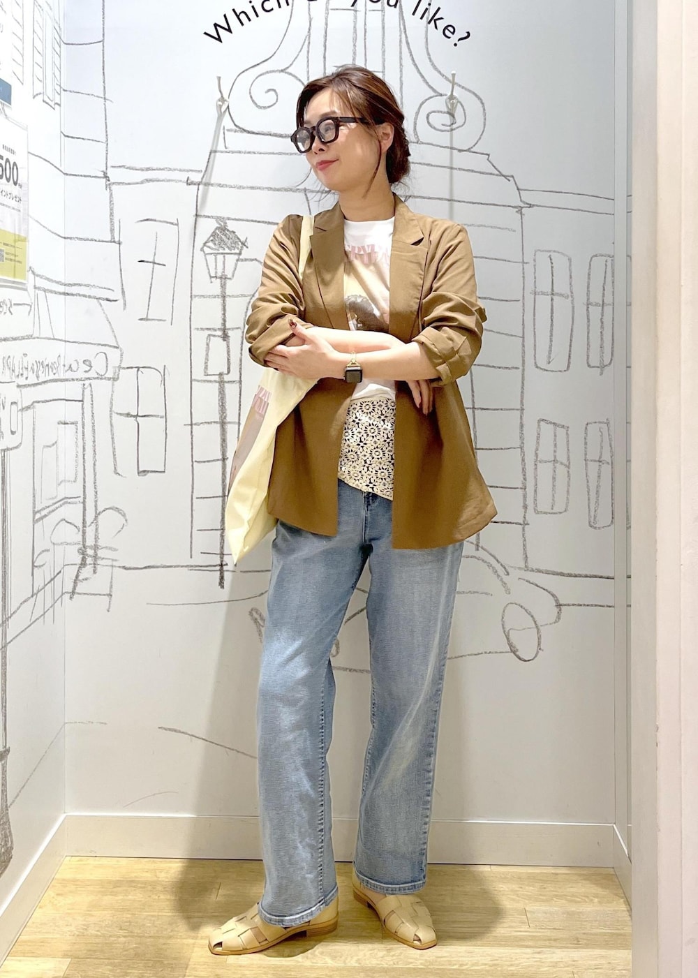ブルー系のデニムパンツ、ベージュ系のサンダル、イエロー系のテーラードジャケットを着用したレディースの春コーディネートの7枚目の写真