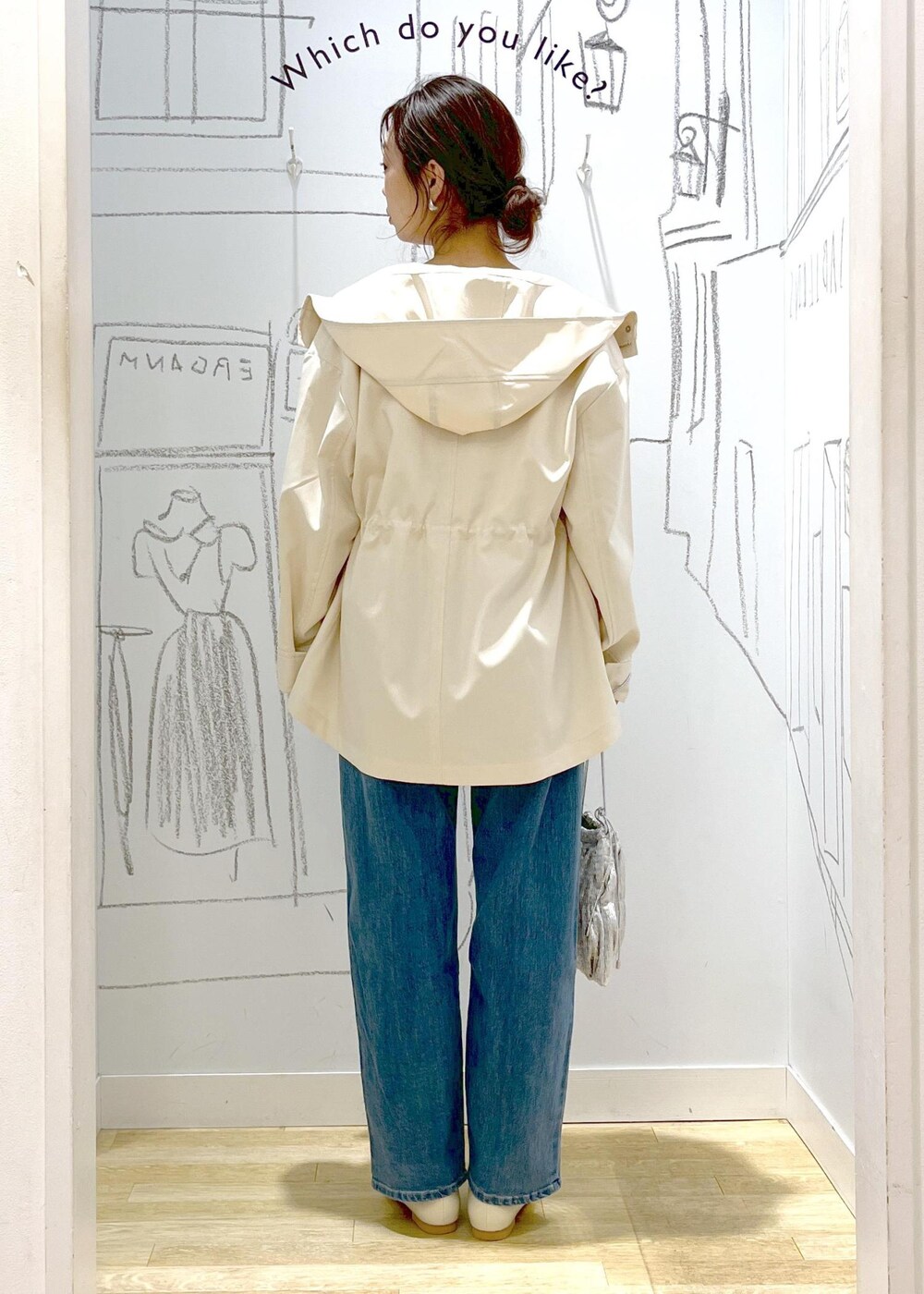 ホワイト系のマウンテンパーカー、シルバー系のショルダーバッグ、ブルー系のデニムパンツを着用したレディースの冬コーディネートの9枚目の写真