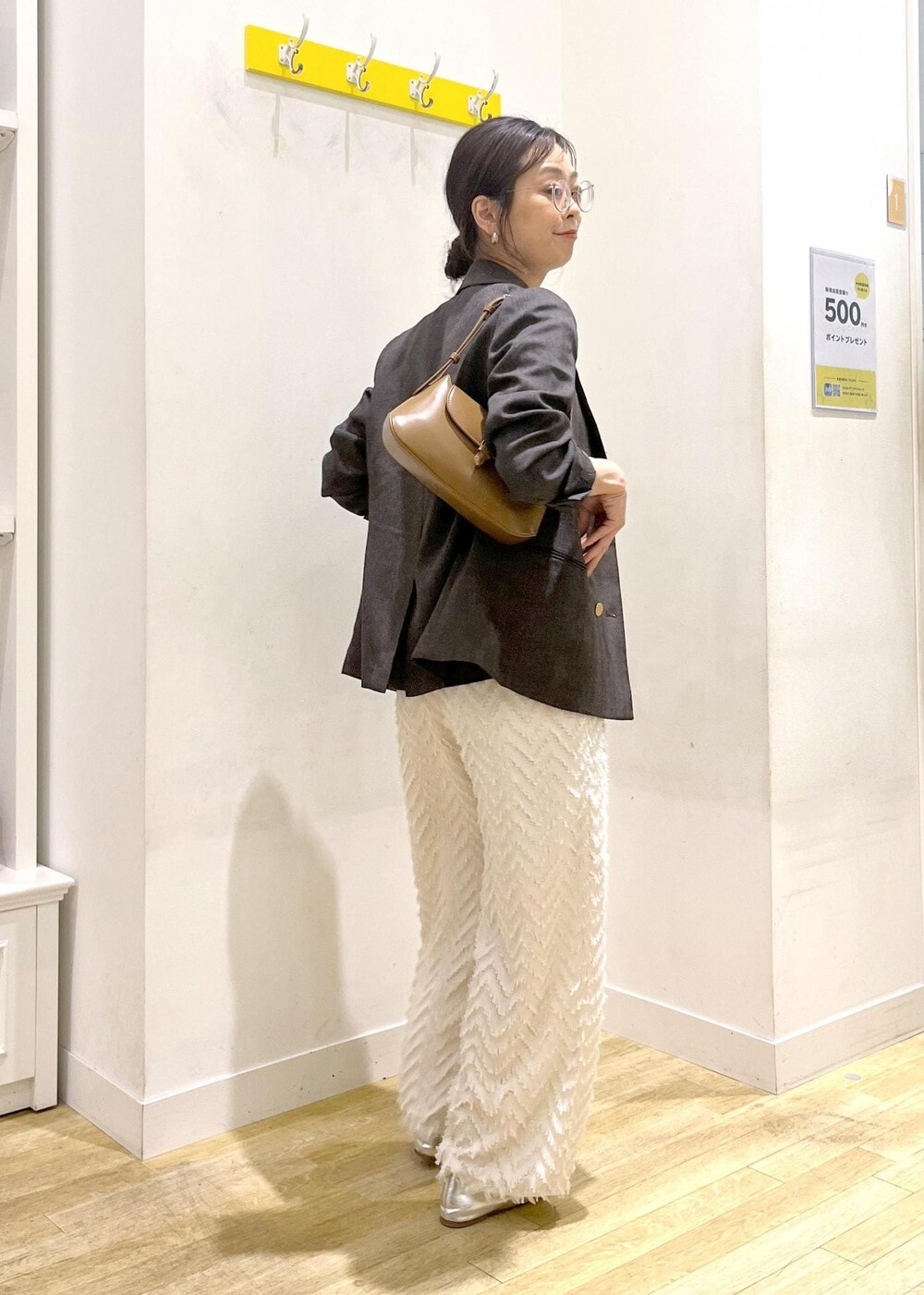 ブラウン系のテーラードジャケット、ブラウン系のショルダーバッグ、グレー系のTシャツ/カットソーを着用したレディースの秋コーディネートの4枚目の写真