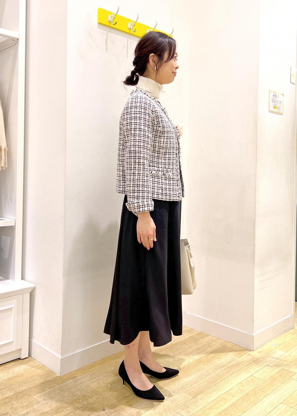 ホワイト系のニット/セーター、ブラック系のドレス、ブラック系のノーカラージャケットを着用したレディースの冬コーディネートの2枚目の写真
