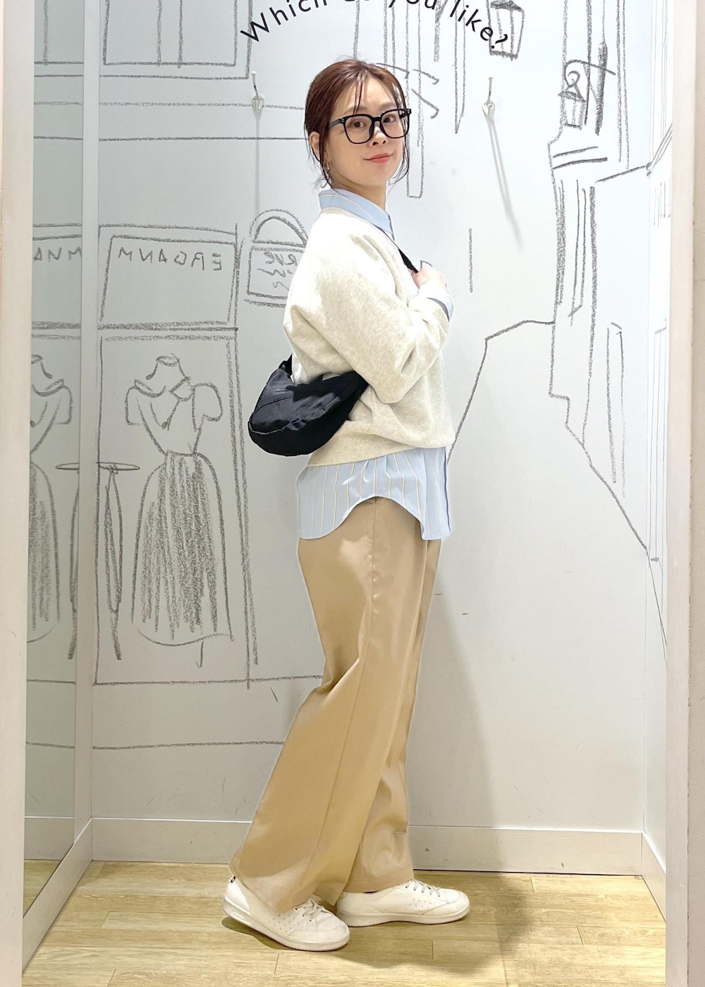 ホワイト系のスウェット、ベージュ系のチノパンツ、ブルー系のシャツ/ブラウスを着用したレディースの春コーディネートの2枚目の写真