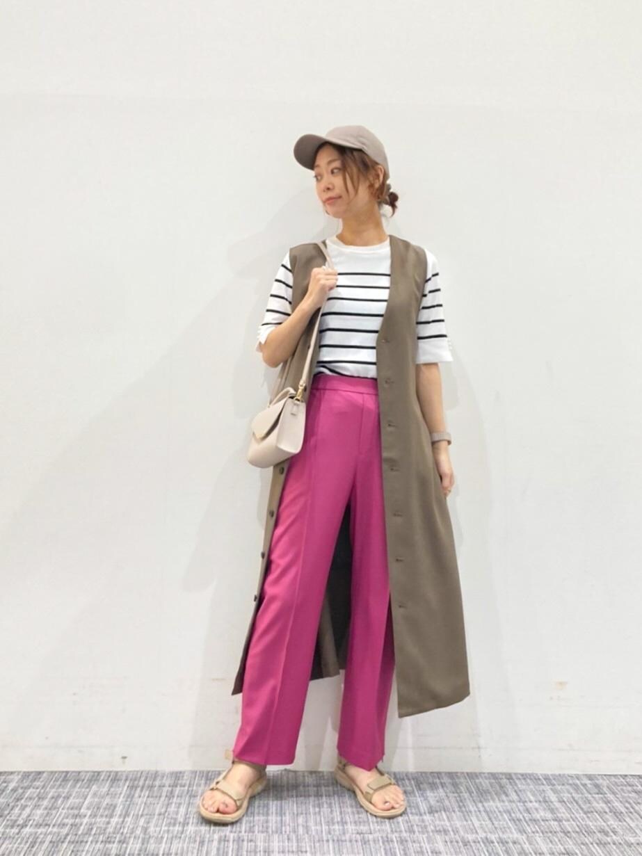 ピンク系のスラックス、ベージュ系のショルダーバッグ、ホワイト系のニット/セーターを着用したレディースの夏コーディネートの3枚目の写真