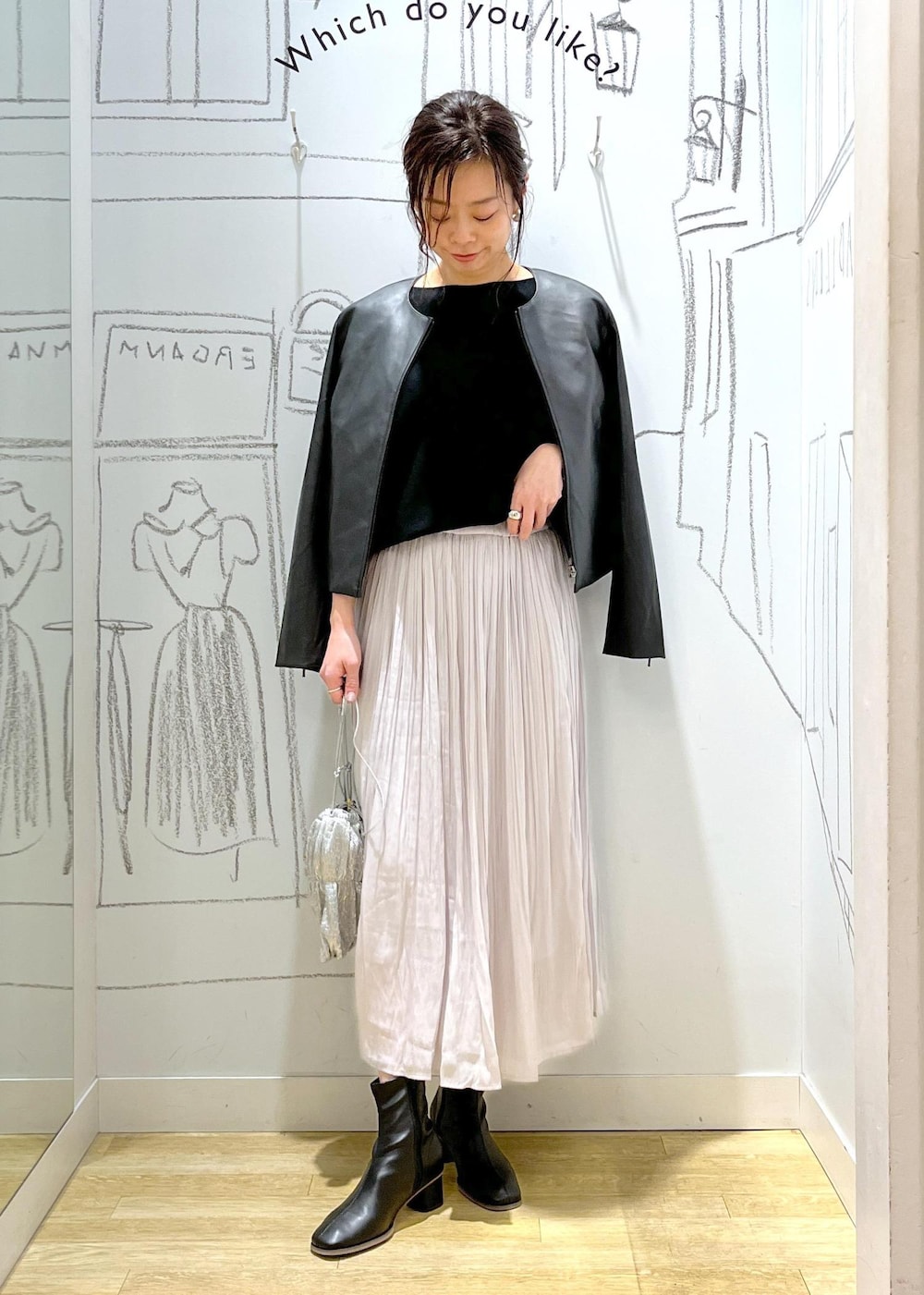 ブラック系のノーカラージャケット、ブラック系のブーツ、シルバー系のショルダーバッグを着用したレディースの冬コーディネートの5枚目の写真