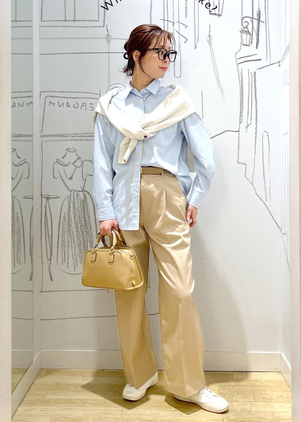 ベージュ系のボストンバッグ、ホワイト系のスウェット、ベージュ系のチノパンツを着用したレディースの春コーディネートの7枚目の写真