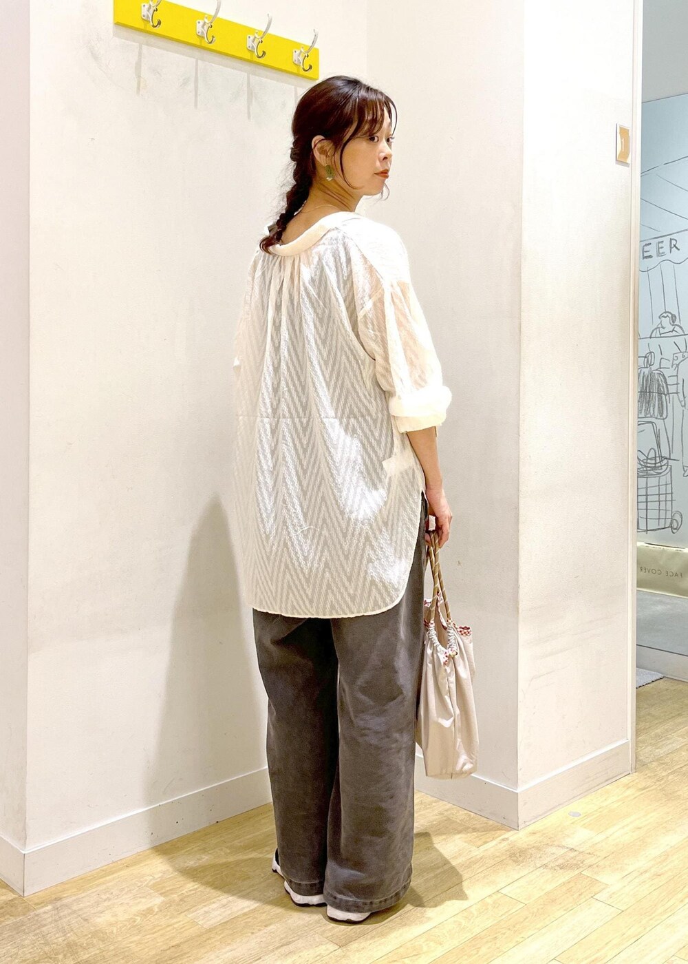 ホワイト系のシャツ/ブラウス、ブラック系のサロペット/オーバーオール、ベージュ系のトートバッグを着用したレディースの秋コーディネートの5枚目の写真