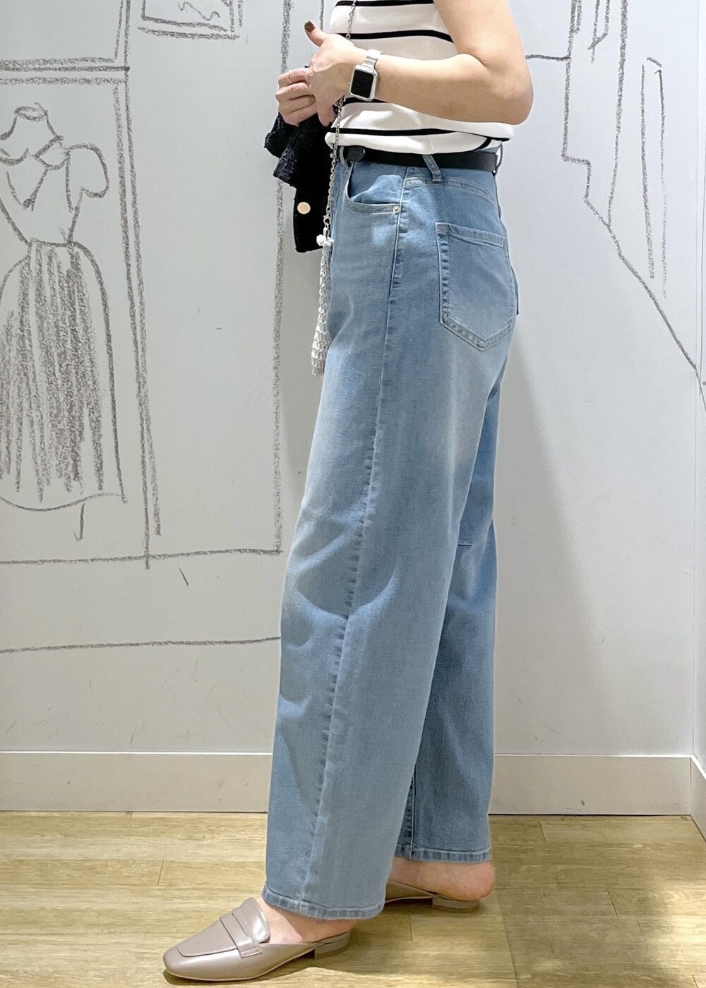 ブルー系のデニムパンツ、グレー系のローファー、ホワイト系のニット/セーターを着用したレディースの夏コーディネートの7枚目の写真