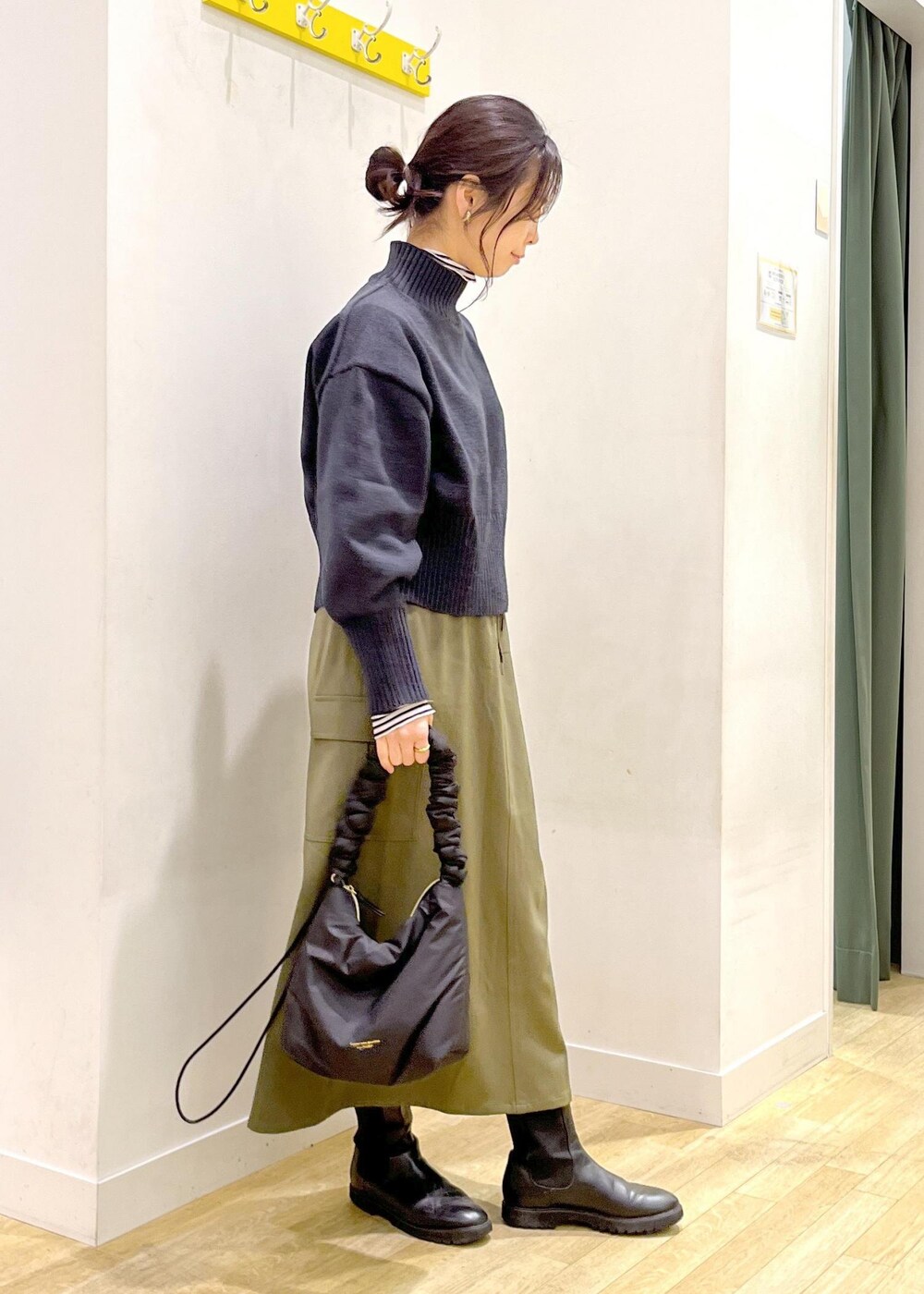 ホワイト系のTシャツ/カットソー、ブラック系のニット/セーター、ブラック系のショルダーバッグを着用したレディースの冬コーディネートの2枚目の写真