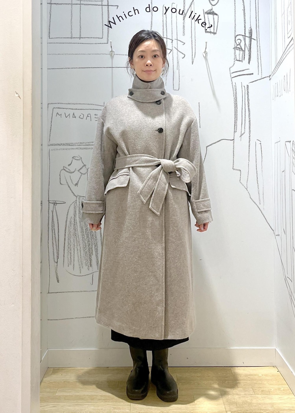 ブラック系のショルダーバッグ、ブラック系のスカート、ベージュ系のチェスターコートを着用したレディースの冬コーディネートの4枚目の写真