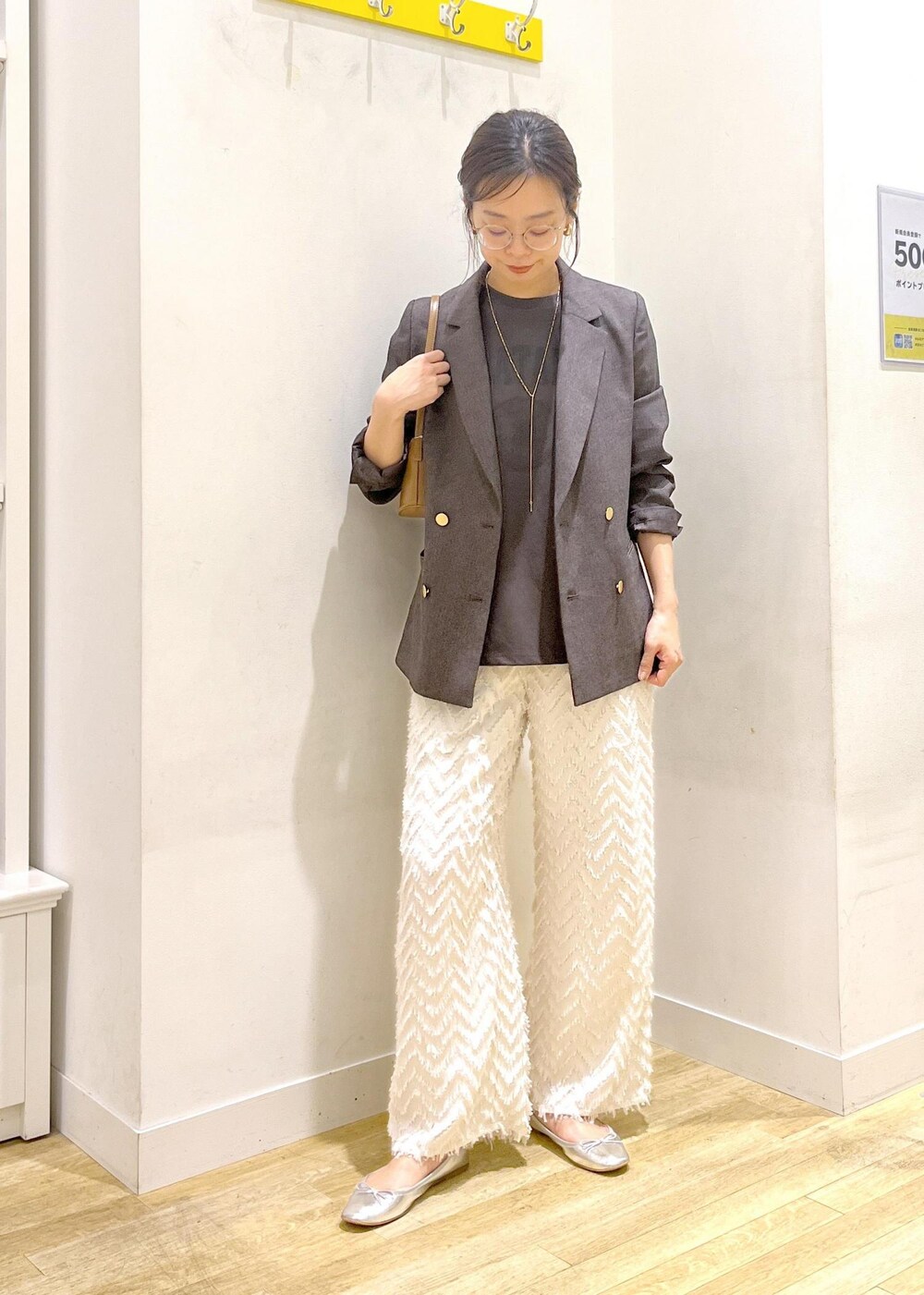 ブラウン系のテーラードジャケット、ブラウン系のショルダーバッグ、グレー系のTシャツ/カットソーを着用したレディースの秋コーディネートの3枚目の写真