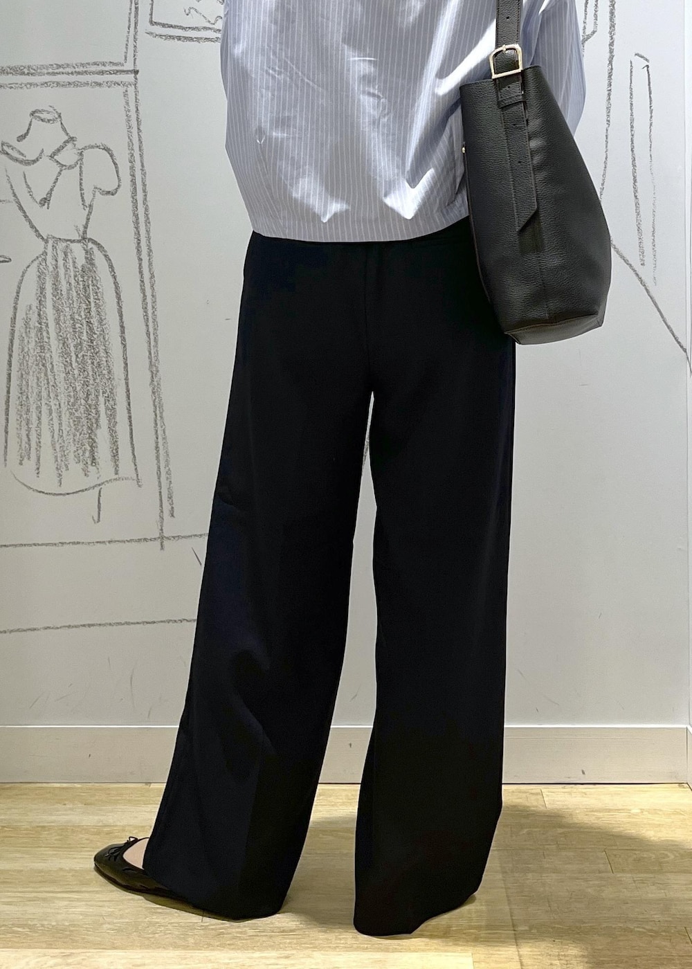 ブラック系のバレエシューズ、ブラック系のショルダーバッグ、ブルー系のスラックスを着用したレディースの秋コーディネートの7枚目の写真