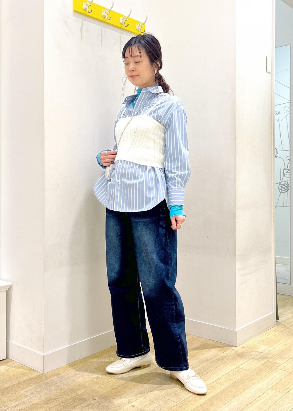 ブルー系のTシャツ/カットソー、ホワイト系のベスト、ブルー系のシャツ/ブラウスを着用したレディースの春コーディネートの4枚目の写真