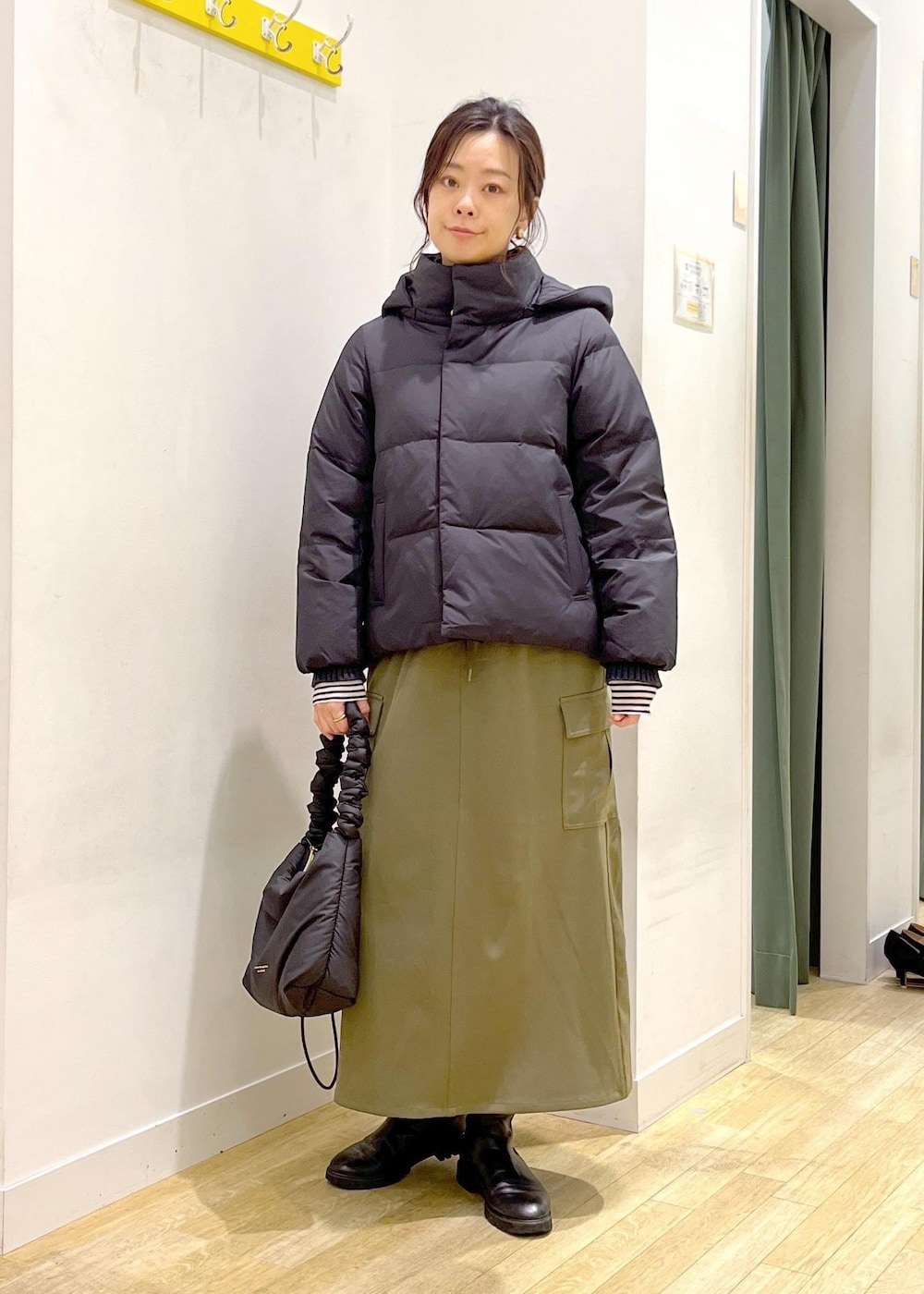 ホワイト系のTシャツ/カットソー、ブラック系のニット/セーター、ブラック系のダウンジャケット/コートを着用したレディースの冬コーディネートの2枚目の写真