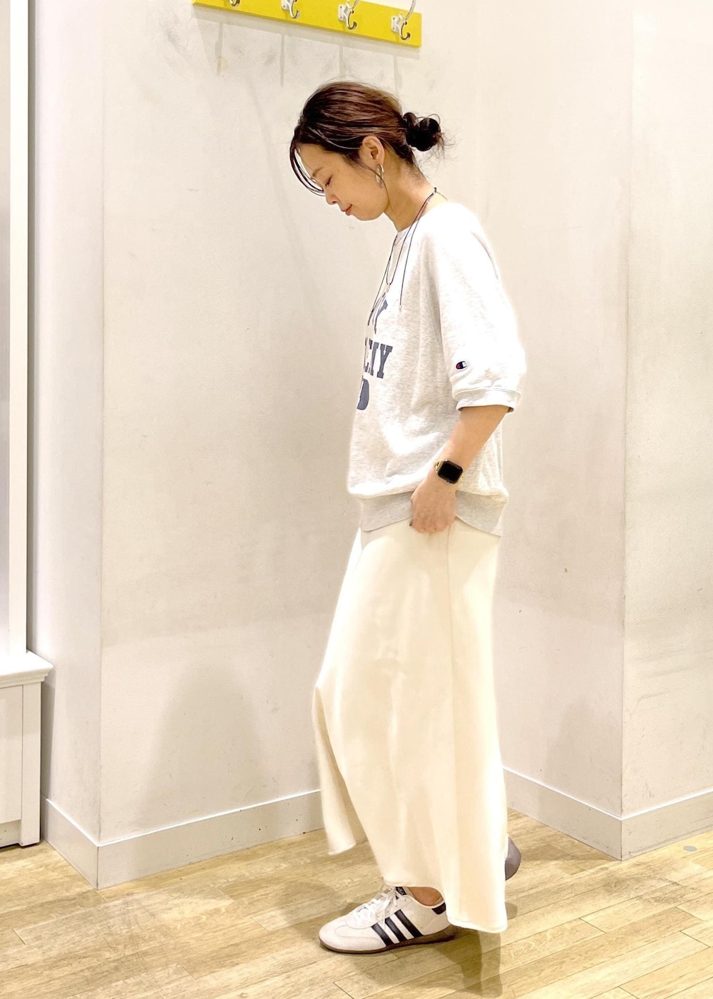 ホワイト系のスカート、グレー系のTシャツ/カットソー、ホワイト系のスニーカーを着用したレディースの夏コーディネートの4枚目の写真