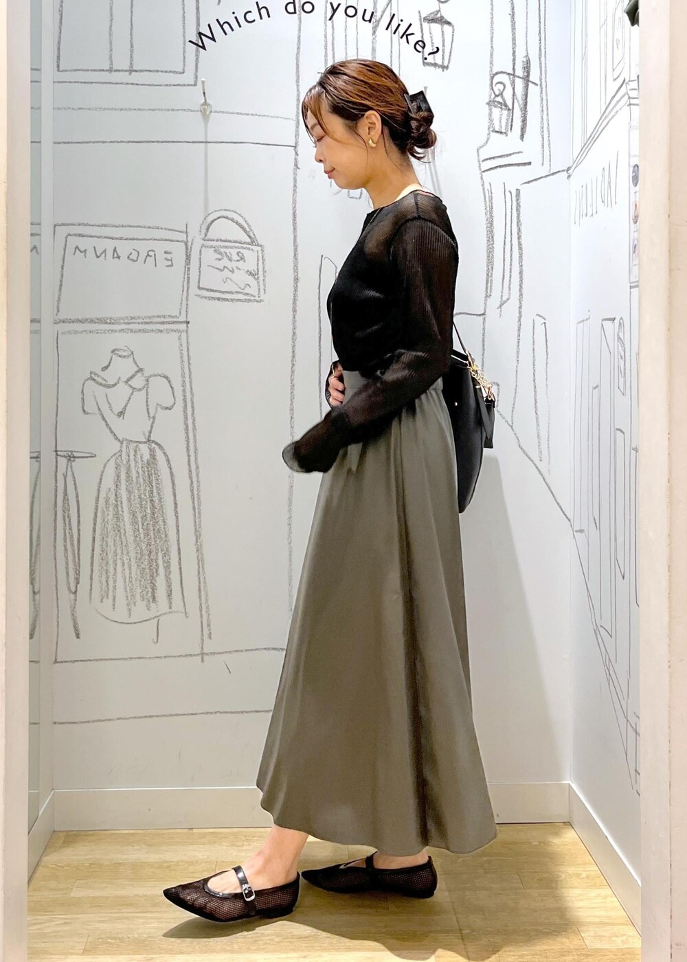 ブラック系のTシャツ/カットソー、ブラック系のショルダーバッグ、グリーン系のスカートを着用したレディースの秋コーディネートの6枚目の写真