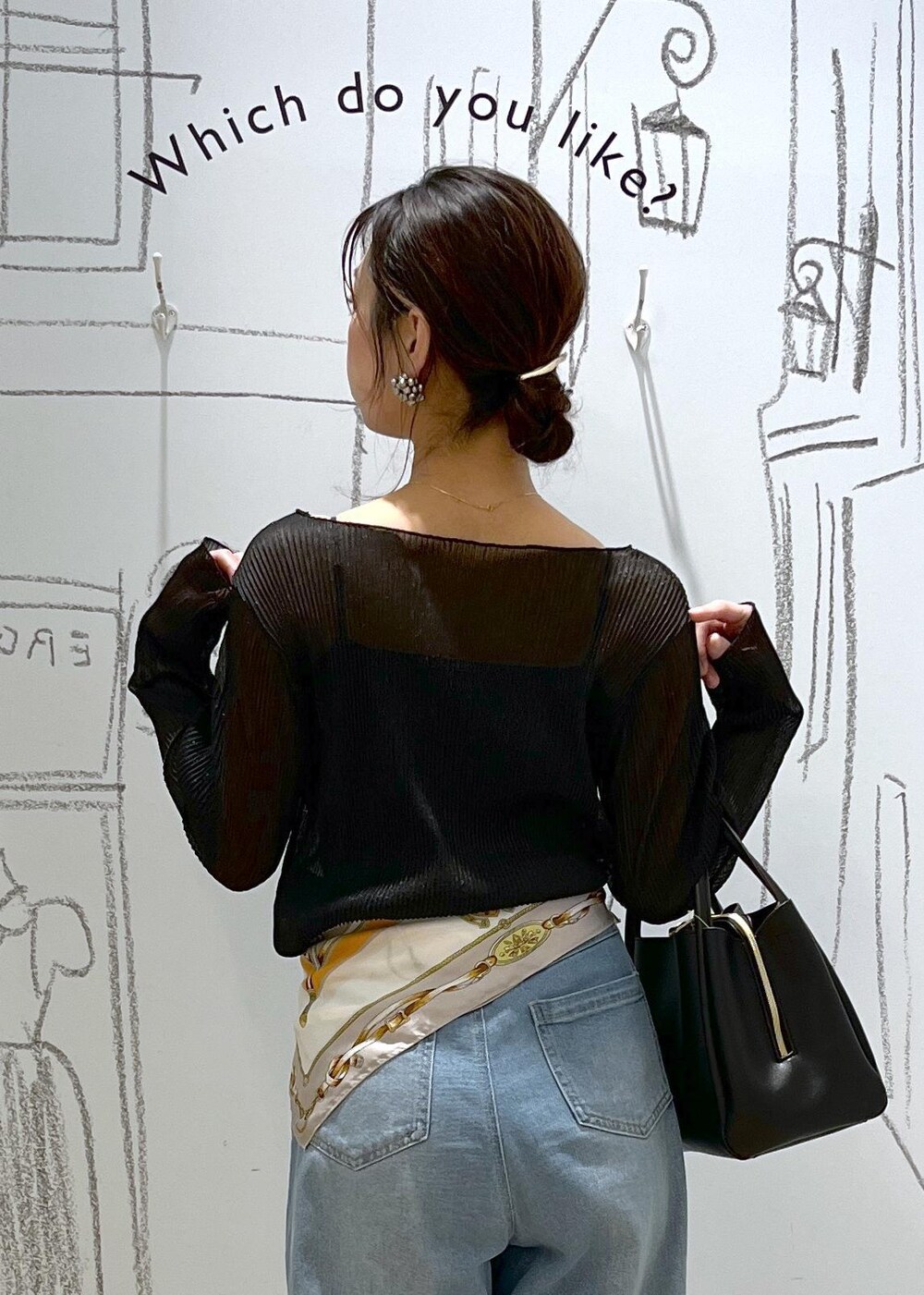 ブラック系のショルダーバッグ、ブラック系のTシャツ/カットソー、ブルー系のデニムパンツを着用したレディースの春コーディネートの8枚目の写真