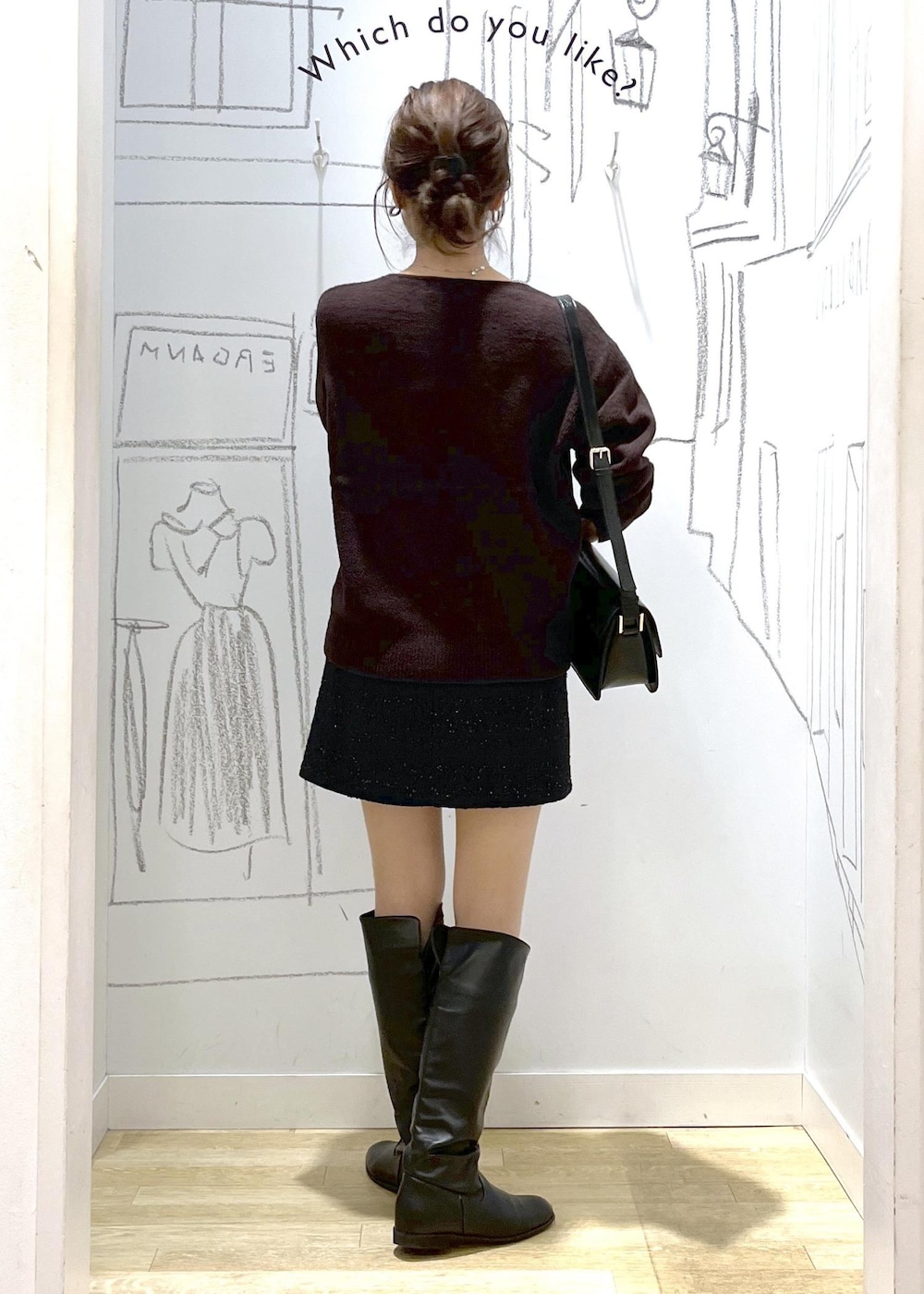 ブラック系のショルダーバッグ、ブラウン系のニット/セーター、ブラック系のダウンジャケット/コートを着用したレディースの冬コーディネートの4枚目の写真