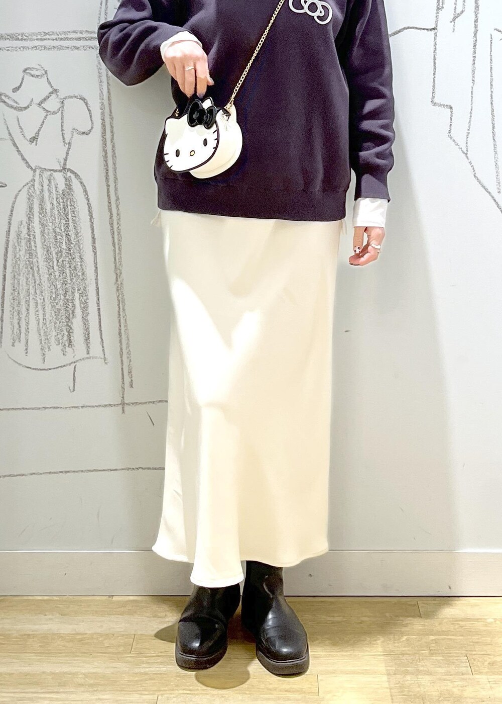 ホワイト系のTシャツ/カットソー、ホワイト系のスカート、グレー系のニット/セーターを着用したレディースの冬コーディネートの7枚目の写真