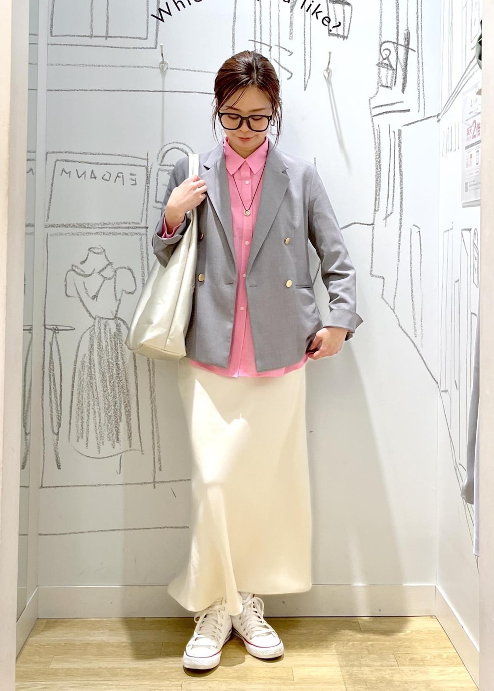 シルバー系のトートバッグ、グレー系のベスト、ホワイト系のスカートを着用したレディースの春コーディネートの3枚目の写真