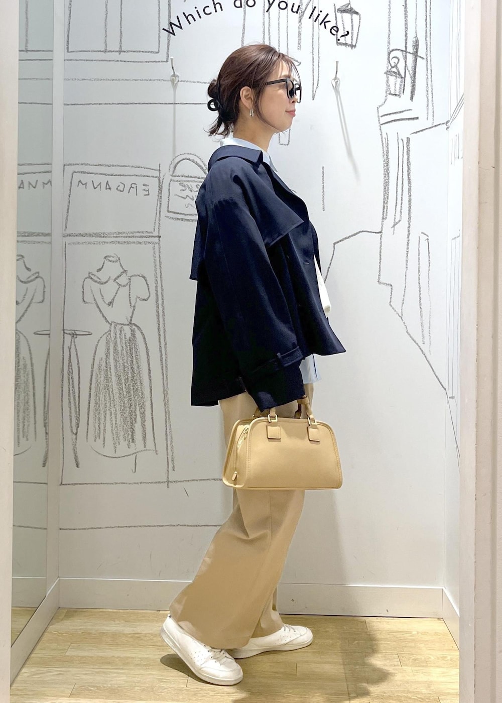 ベージュ系のボストンバッグ、ホワイト系のスウェット、ベージュ系のチノパンツを着用したレディースの春コーディネートの5枚目の写真