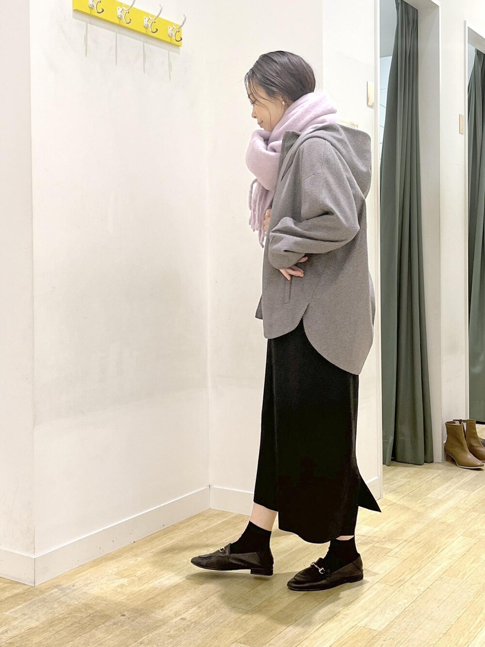 ブラック系のジャンパースカート、ブラウン系のその他アウター、グレー系のショルダーバッグを着用したレディースの冬コーディネートの3枚目の写真