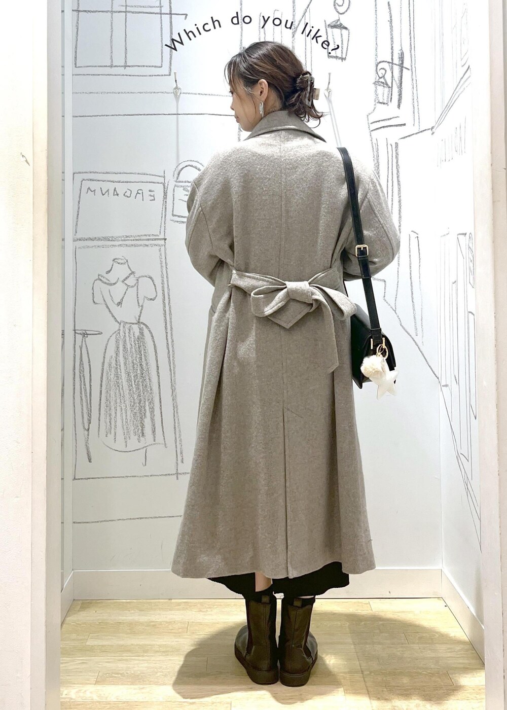 ブラック系のショルダーバッグ、ブラック系のスカート、ベージュ系のチェスターコートを着用したレディースの冬コーディネートの7枚目の写真